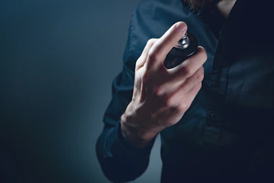 Man spraying perfume on his neck