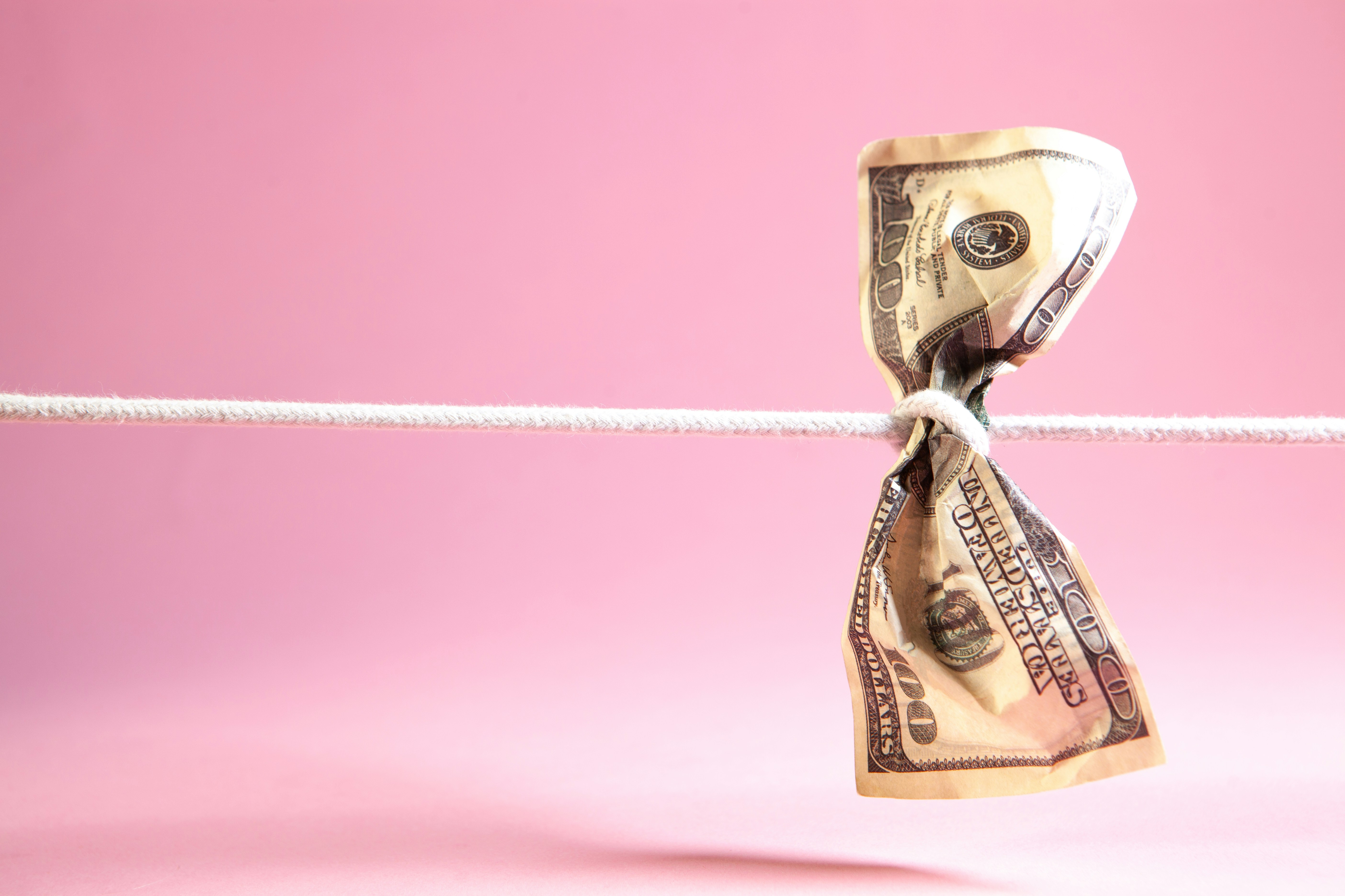 A hundred-dollar bill tied with a string within stock loan hub market