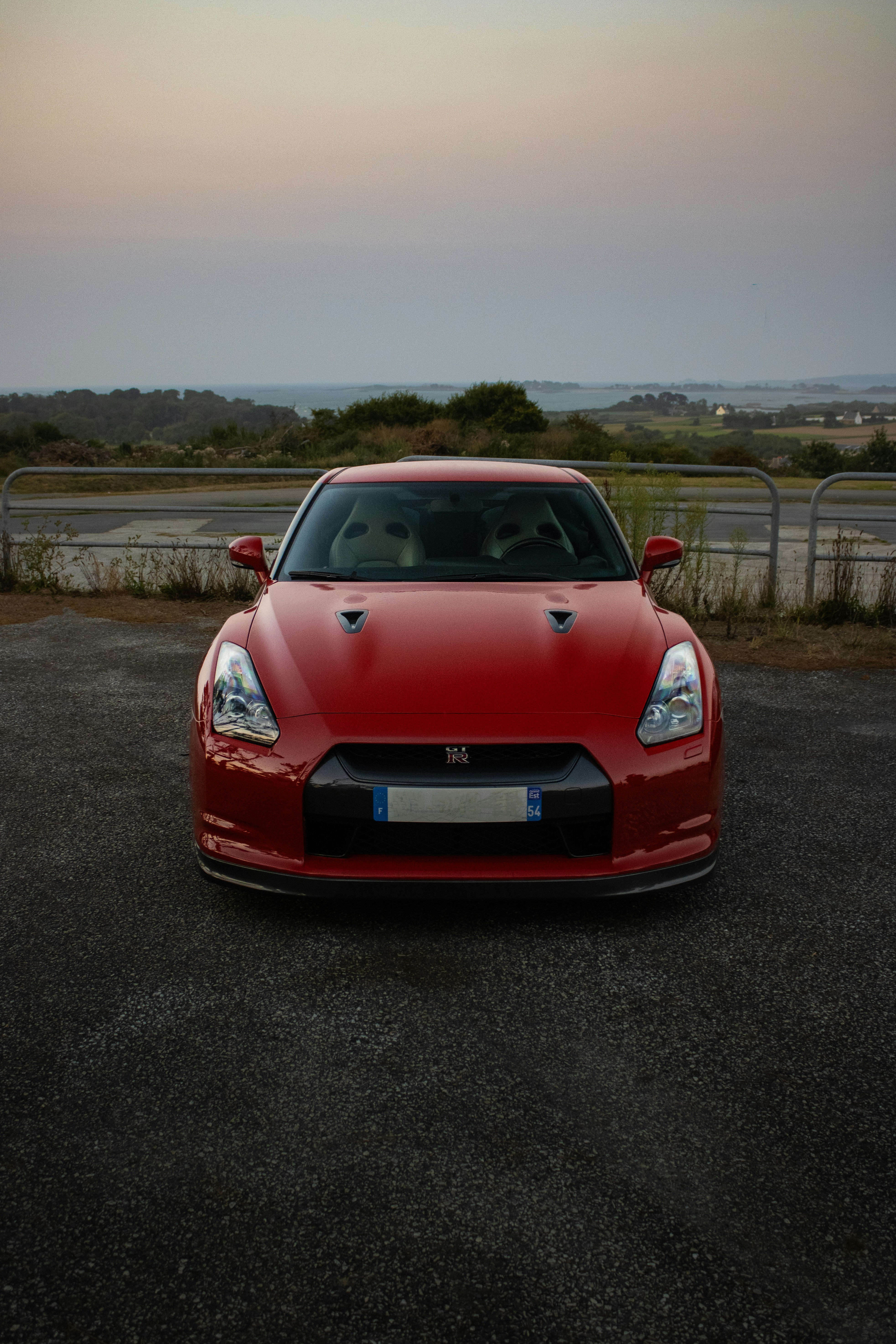 Red nissan gt-r parked outdoors at dusk
