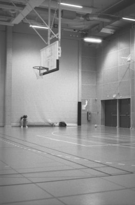 Empty basketball court with hoop and doors