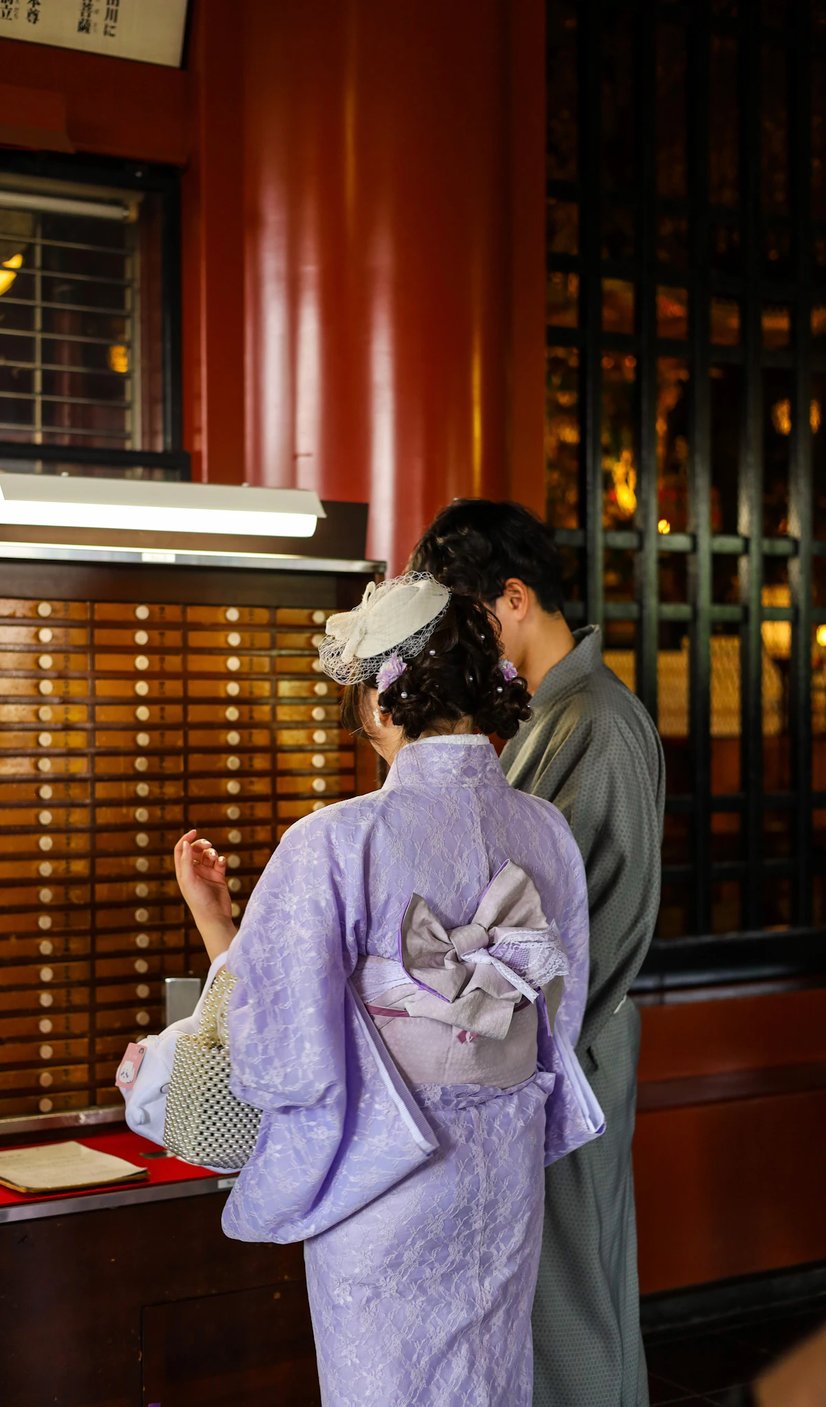 A couple in traditional Japanese attire visiting a shrine in Asakusa, Tokyo