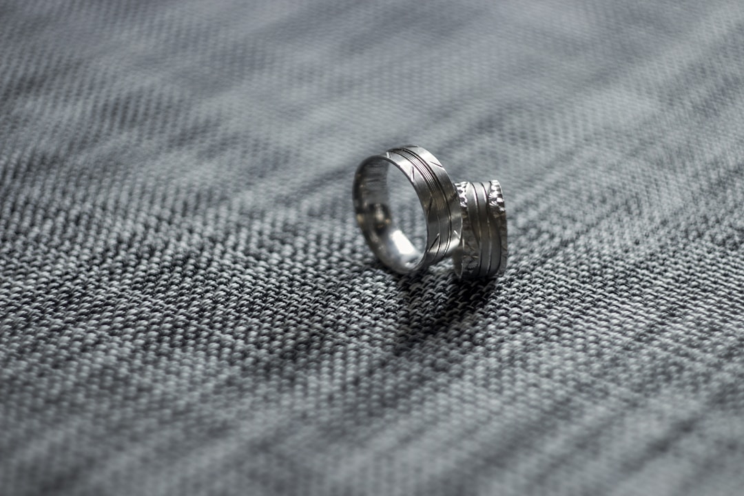 how should a ring fit — two silver men's wedding bands on grey fabric — FoundryCut