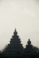 Two ancient stone temples against a hazy sky