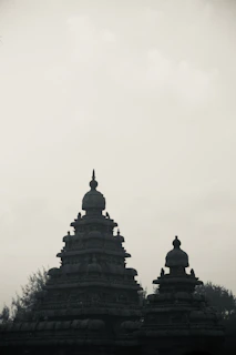 Two ancient stone temples against a hazy sky