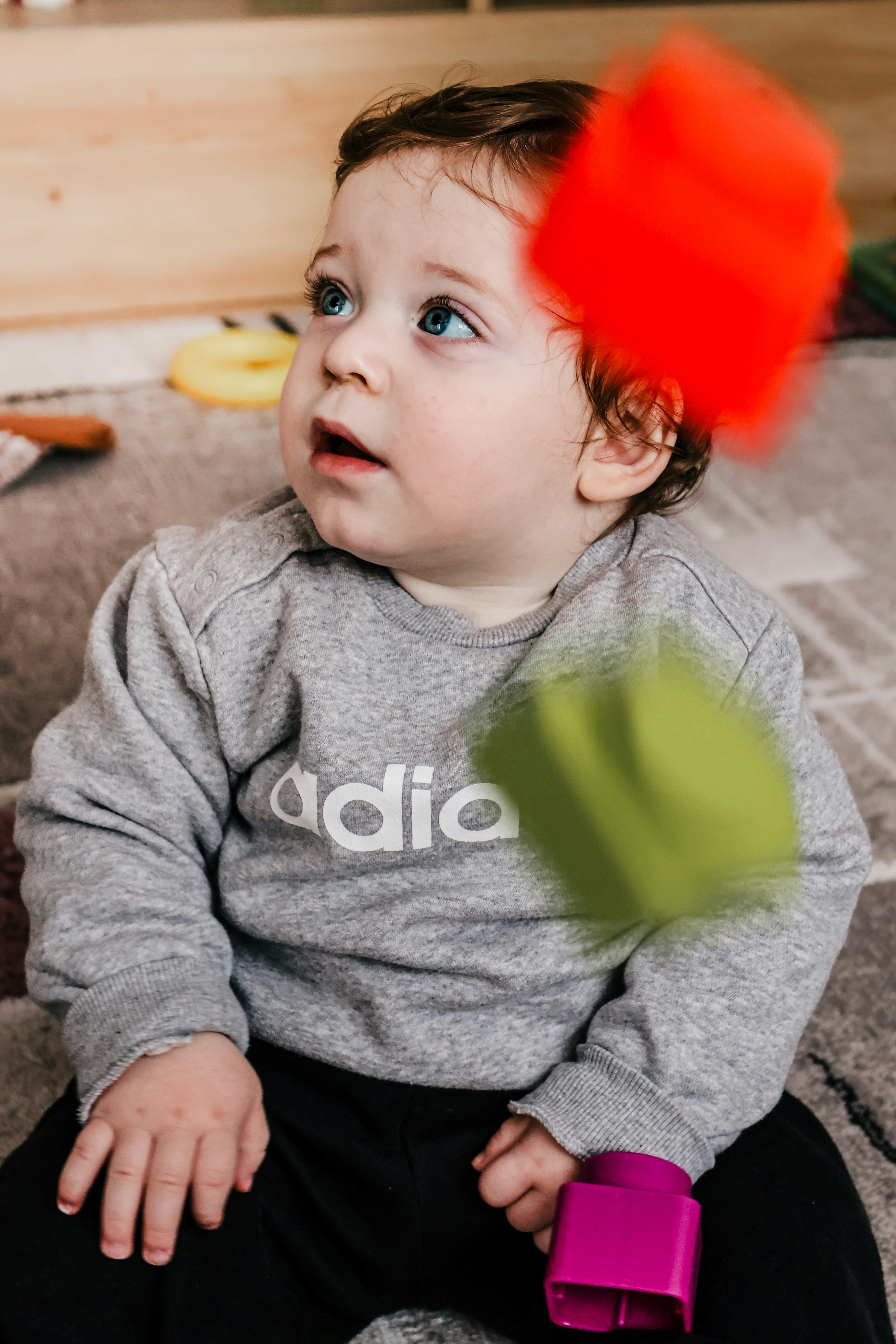 Baby boy looking up at blurred blocks falling blocks