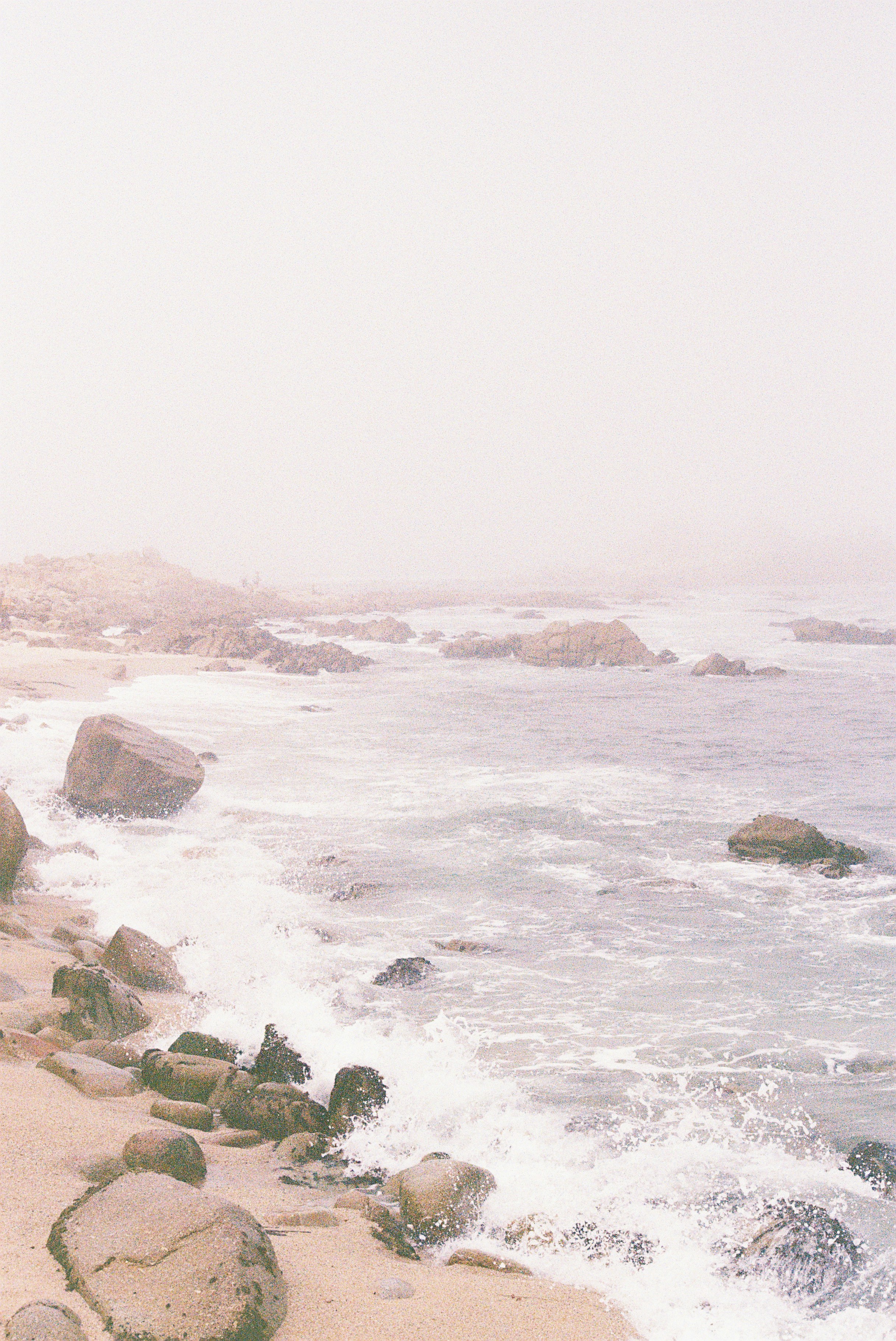Waves crash on a rocky shore in soft light