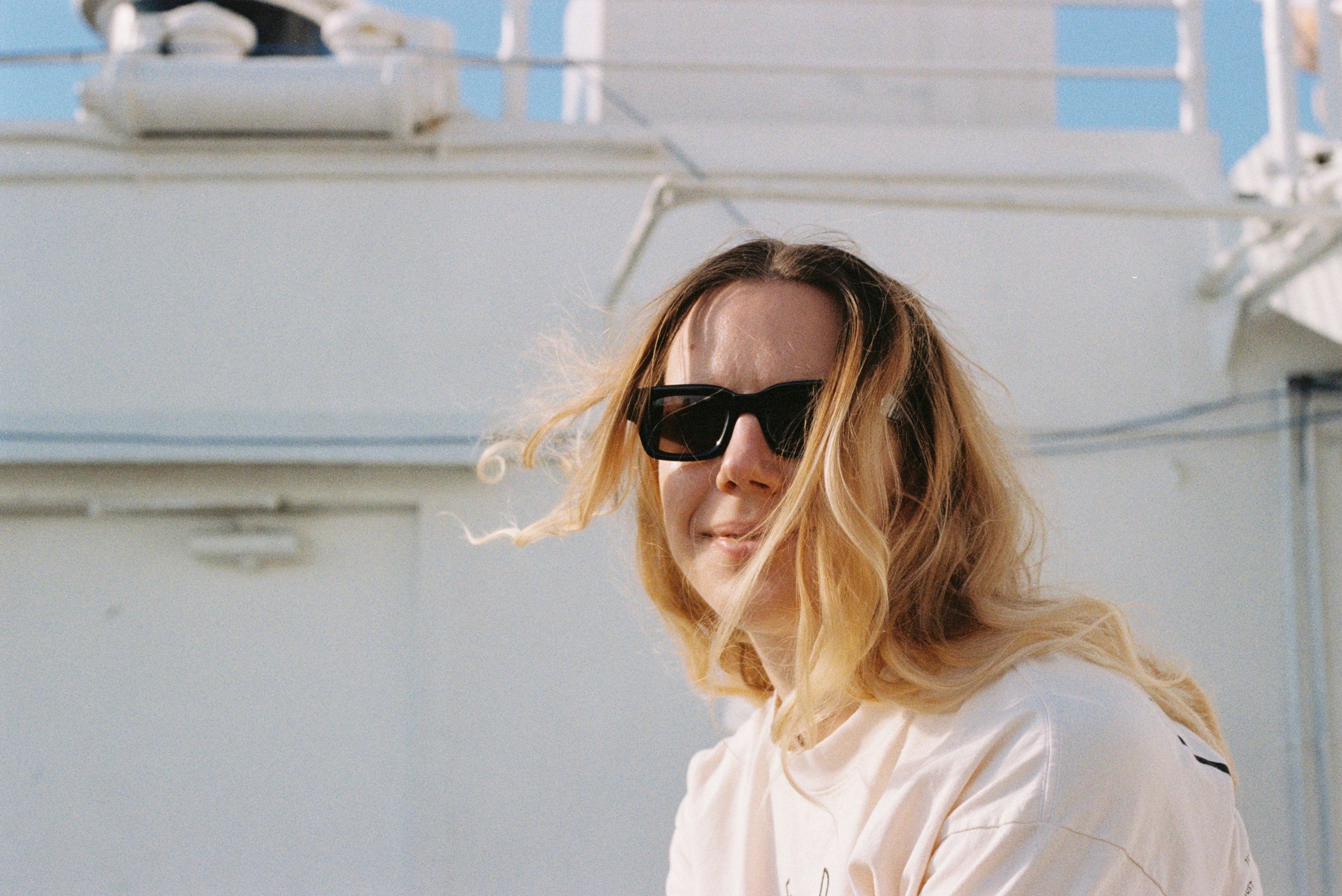 Joven rubia con gafas de sol al aire libre.