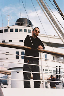 Man leaning on railing of a large ship.
