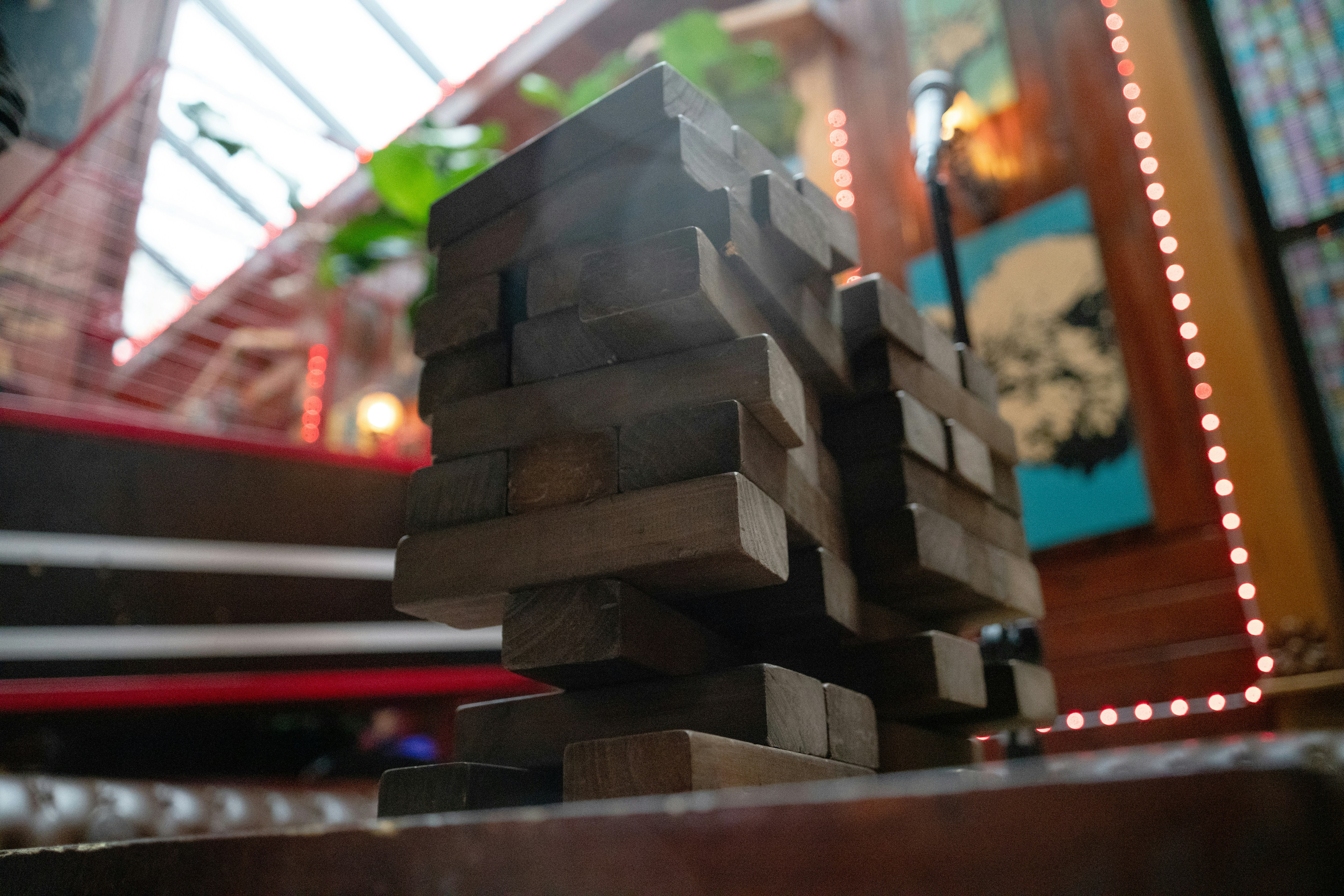 Wooden blocks stacked precariously high indoors.