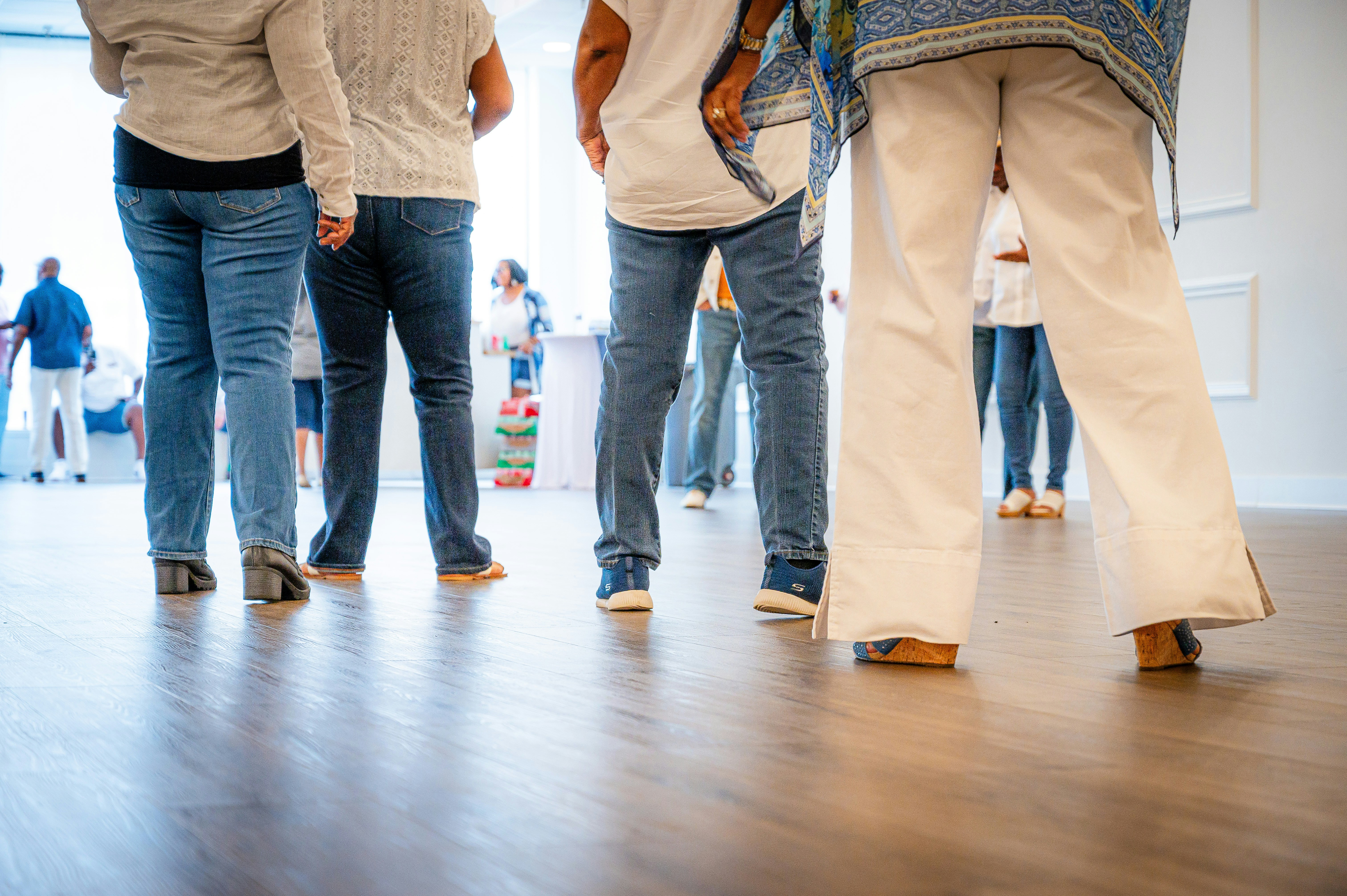 Persone in piedi in una stanza con il pavimento di legno