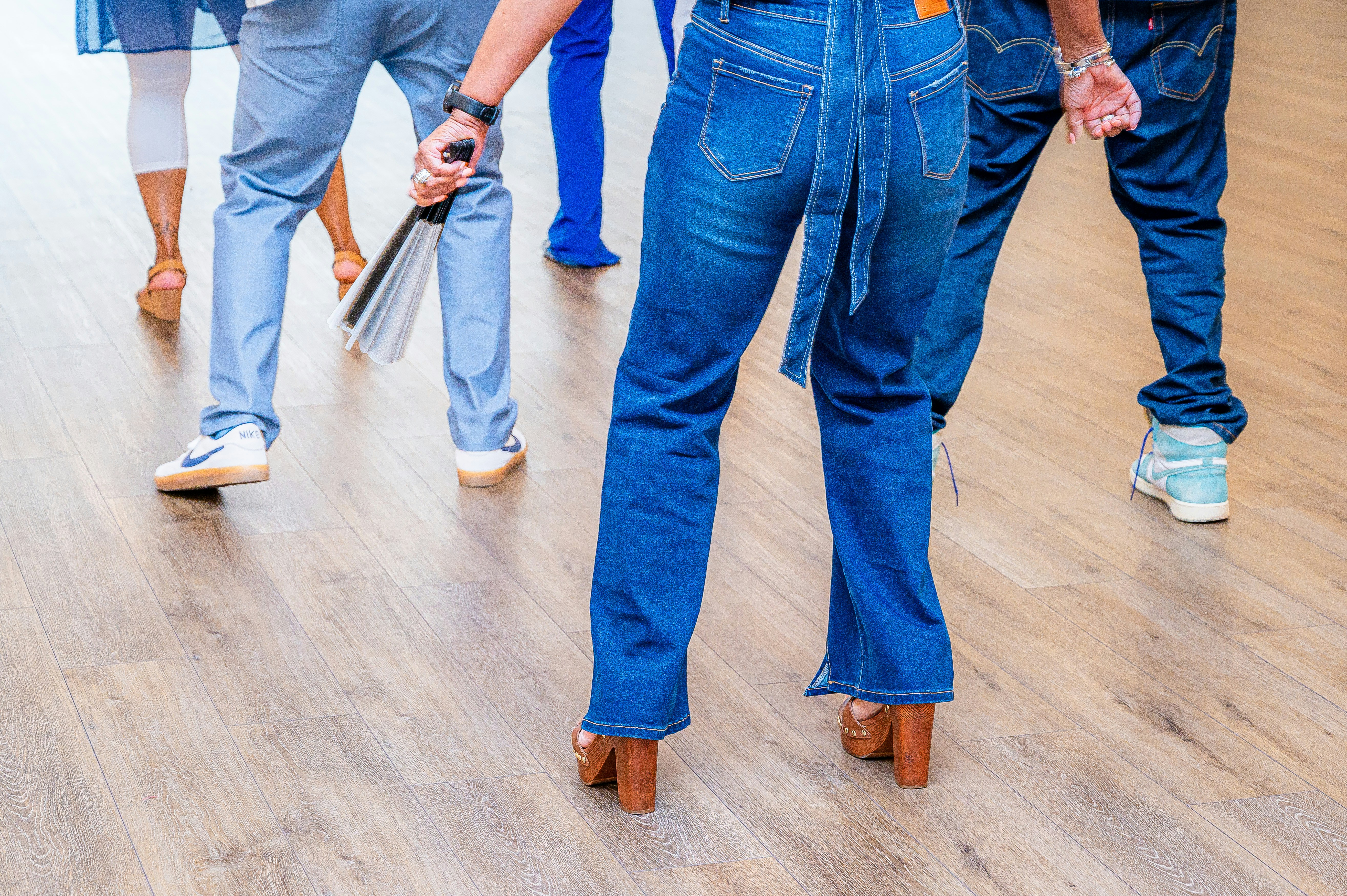 Persone in jeans di jeans che ballano su un pavimento di legno