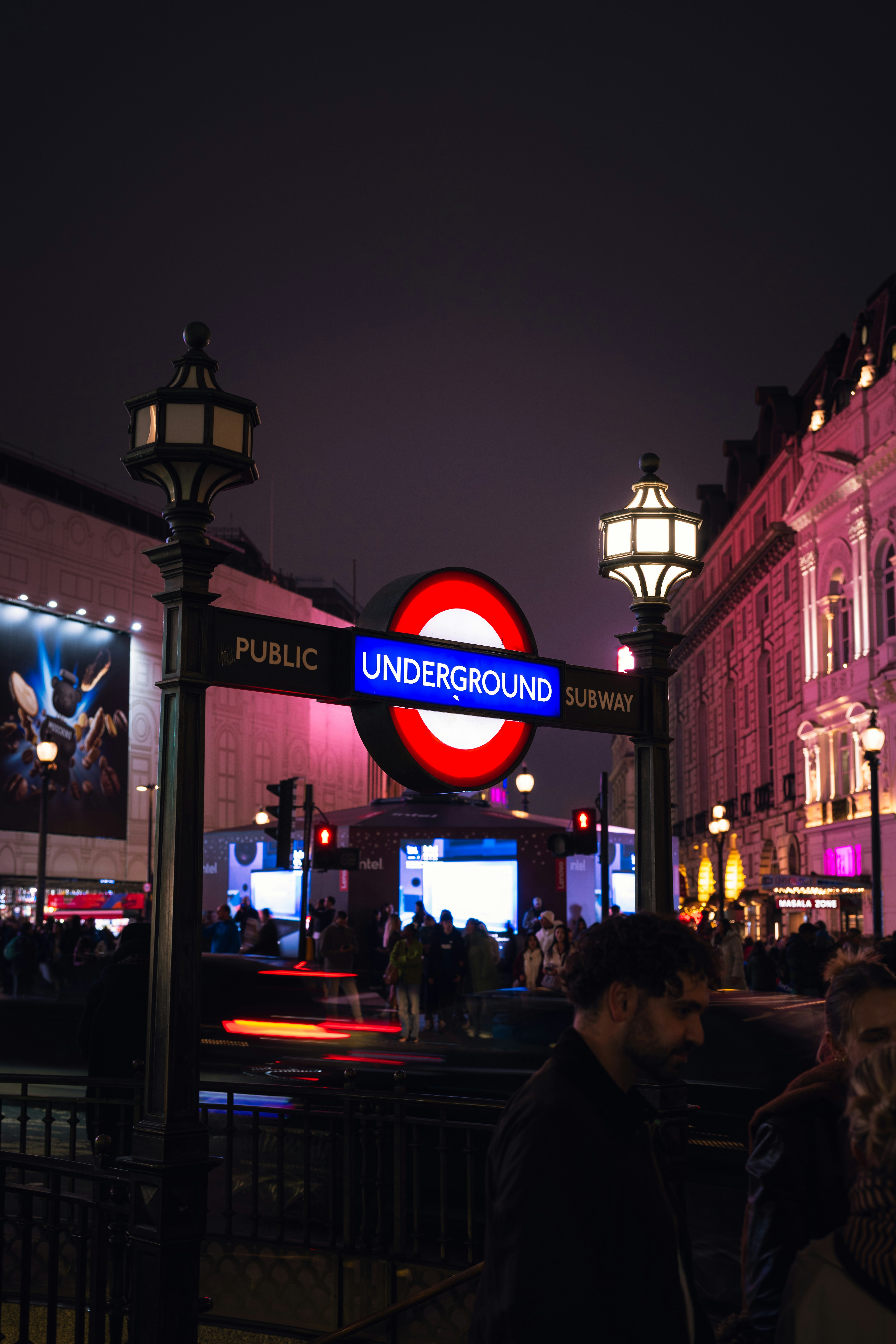 Cartel del metro de Londres por la noche con luces de la ciudad