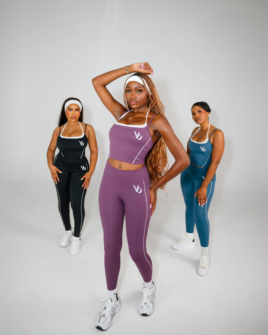 Três mulheres vestindo conjuntos de moda fitness