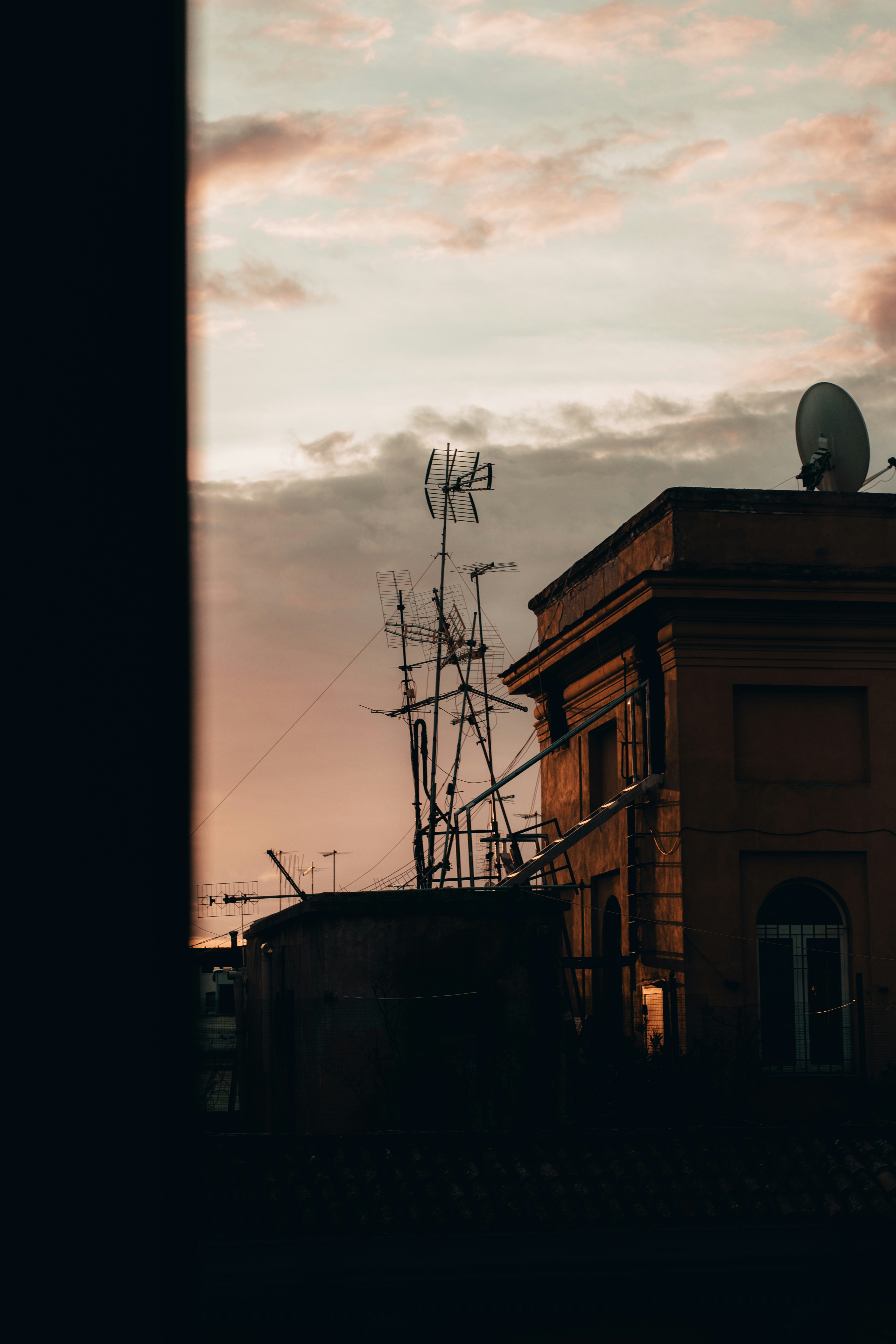 Rooftops and antennas against a dusky sky.