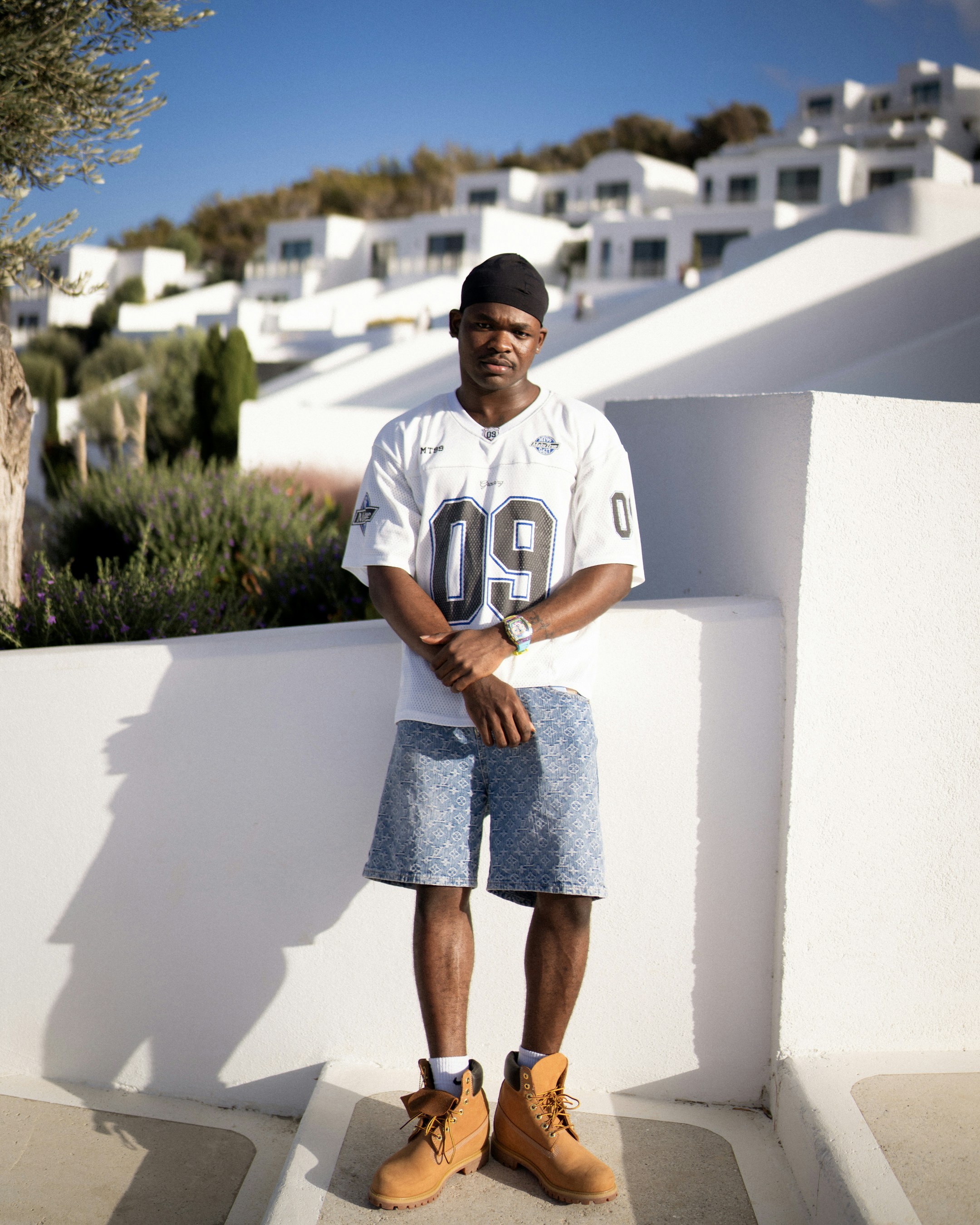 Man in jersey and shorts standing outdoors