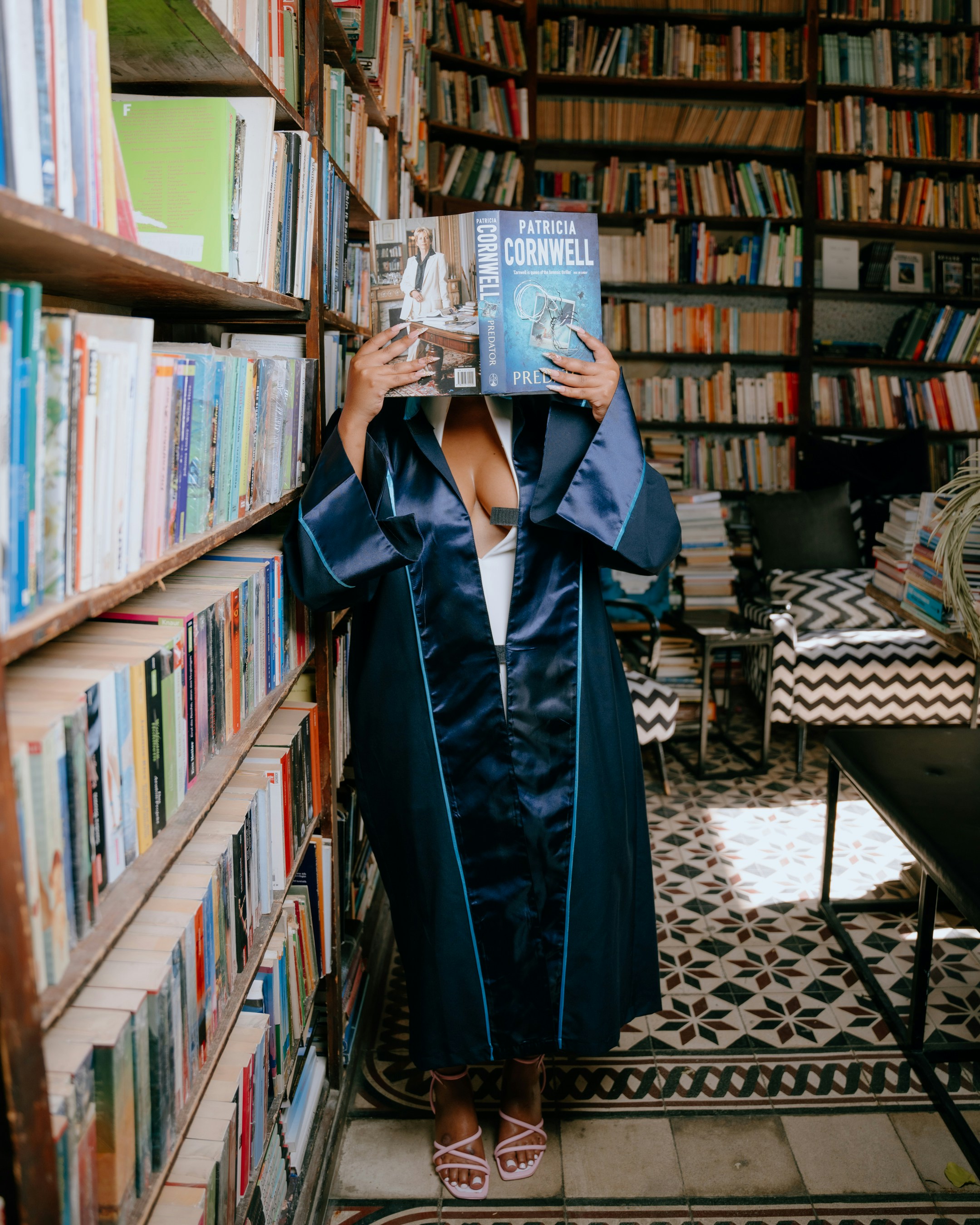 Woman in robe reads book in library