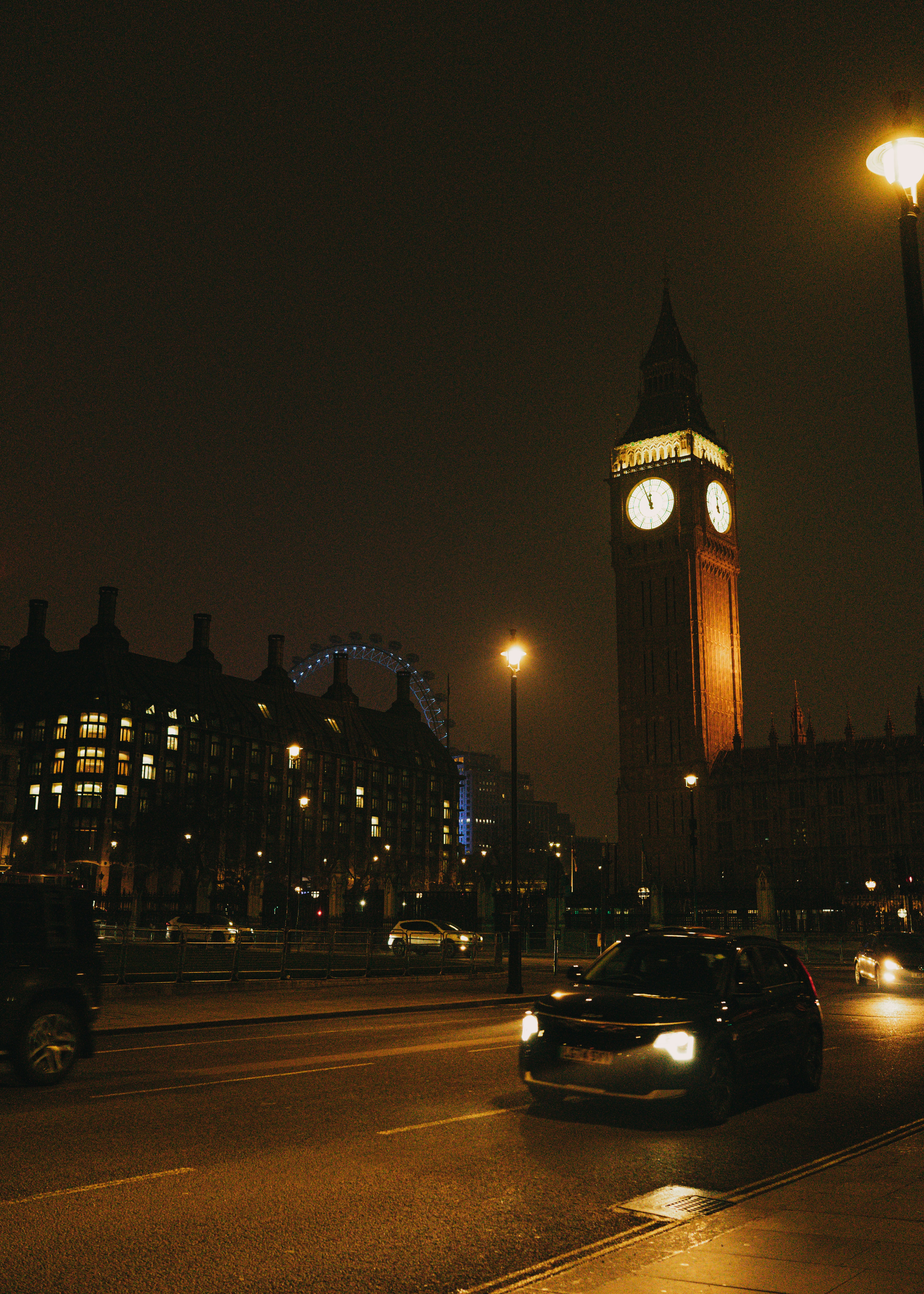 Big ben and london eye at night with traffic