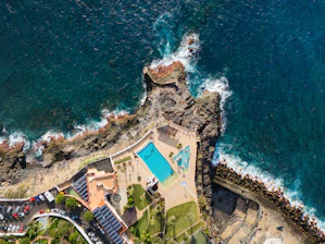 Aerial view of coastal resort with swimming pool and ocean.