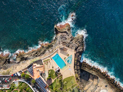 Aerial view of coastal resort with swimming pool and ocean.