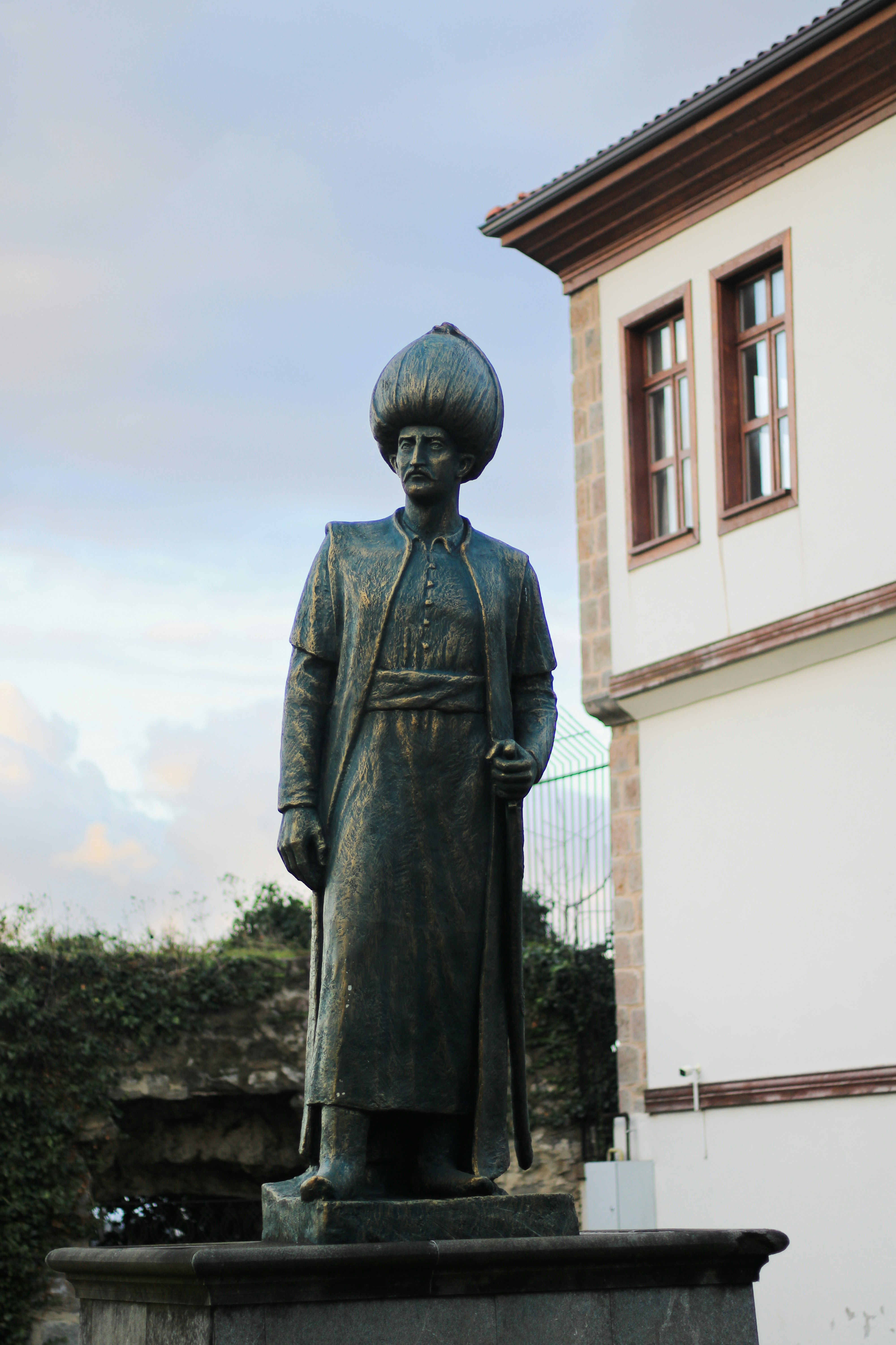 Bronze statue of a man in historical attire.