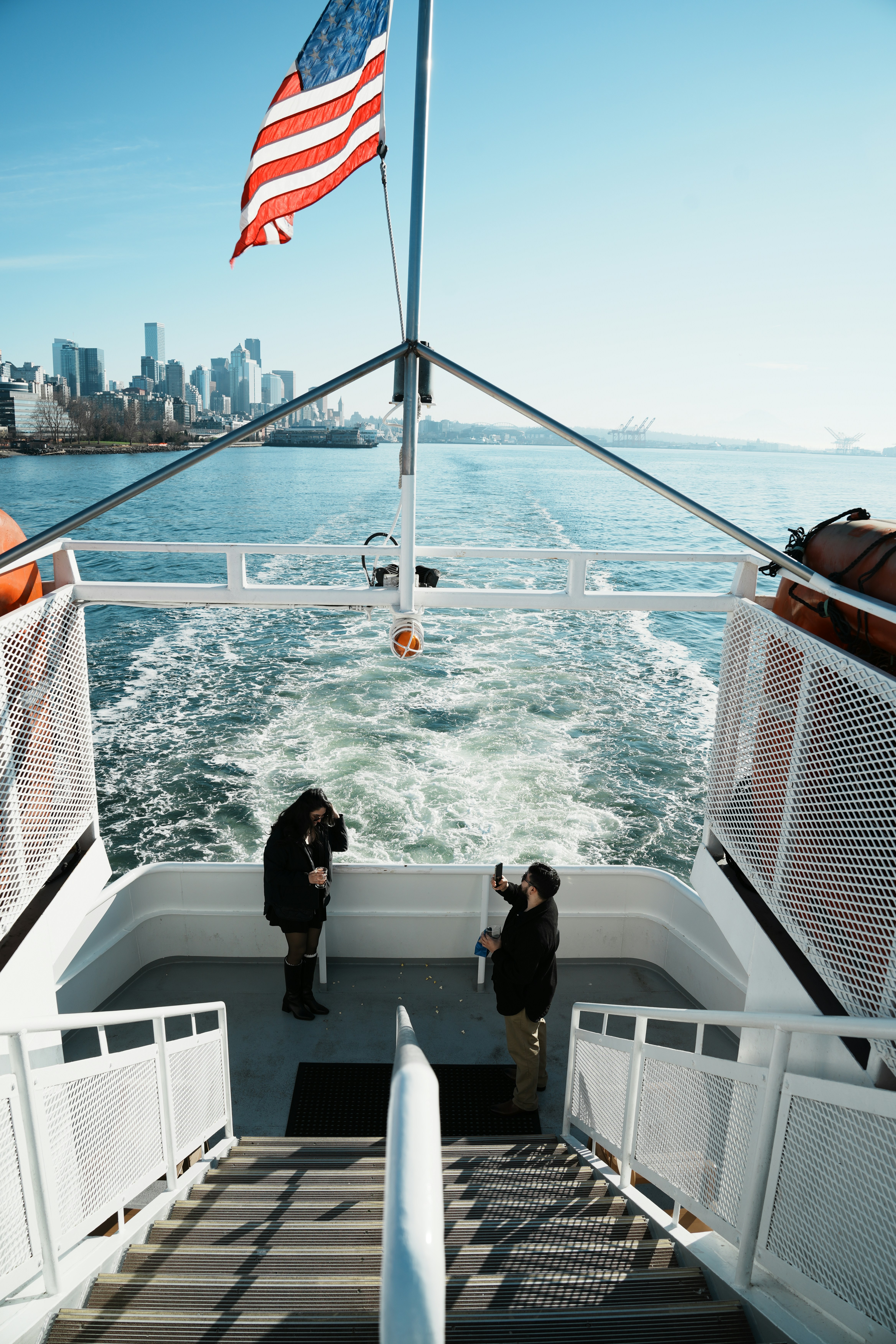 Dos personas en un ferry con bandera americana.