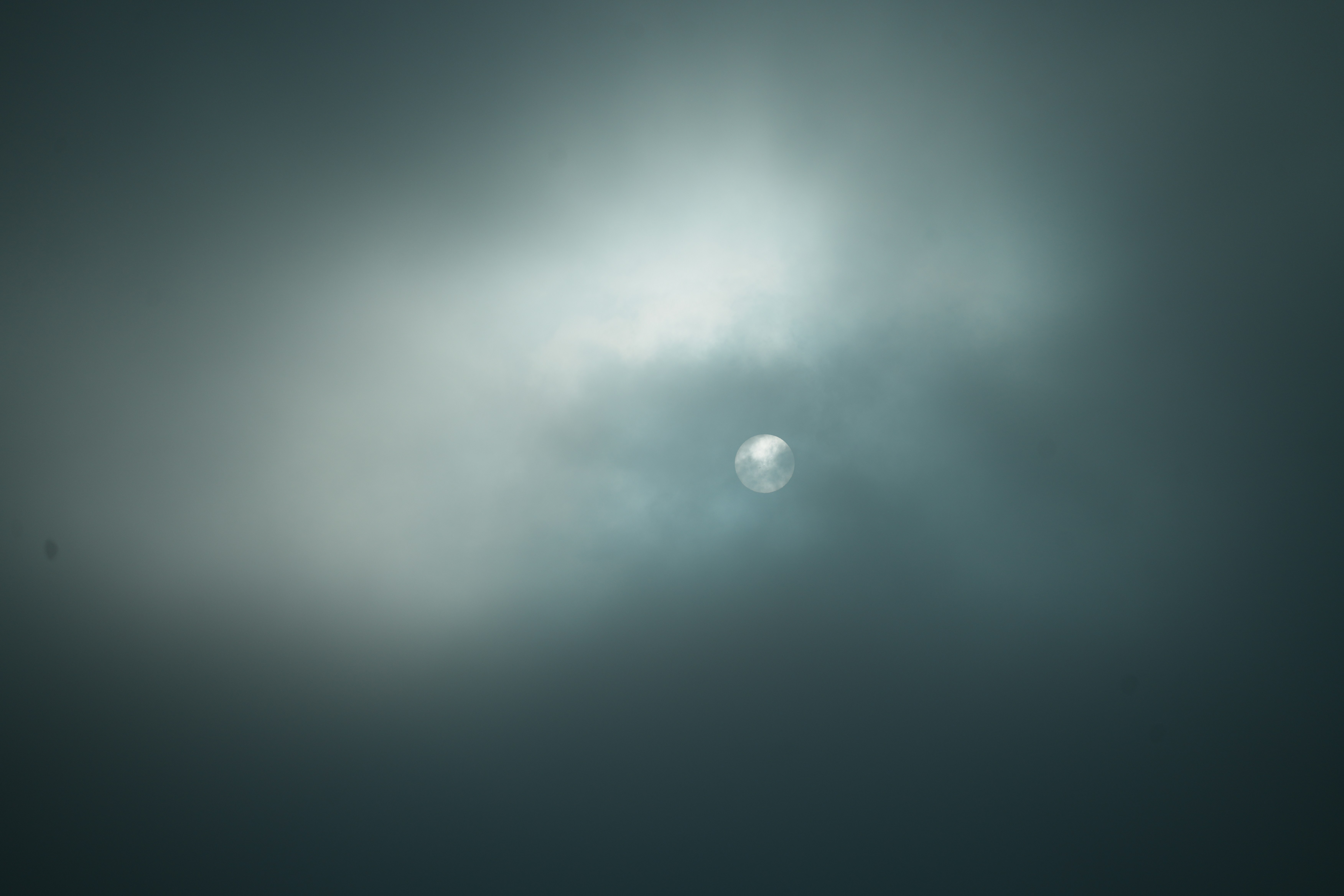 Sun partially obscured by dark clouds