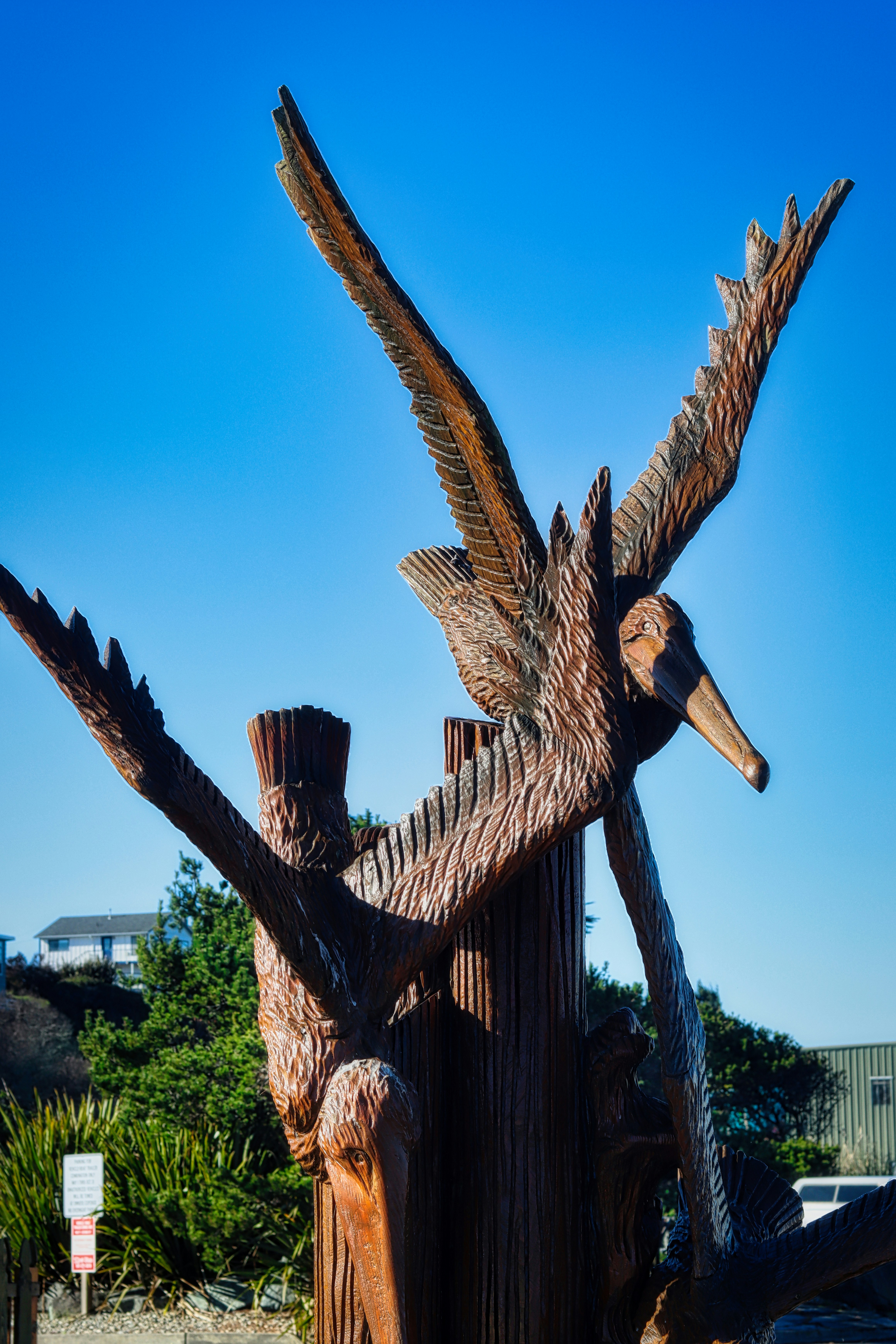 Wooden sculpture of birds in flight against blue sky