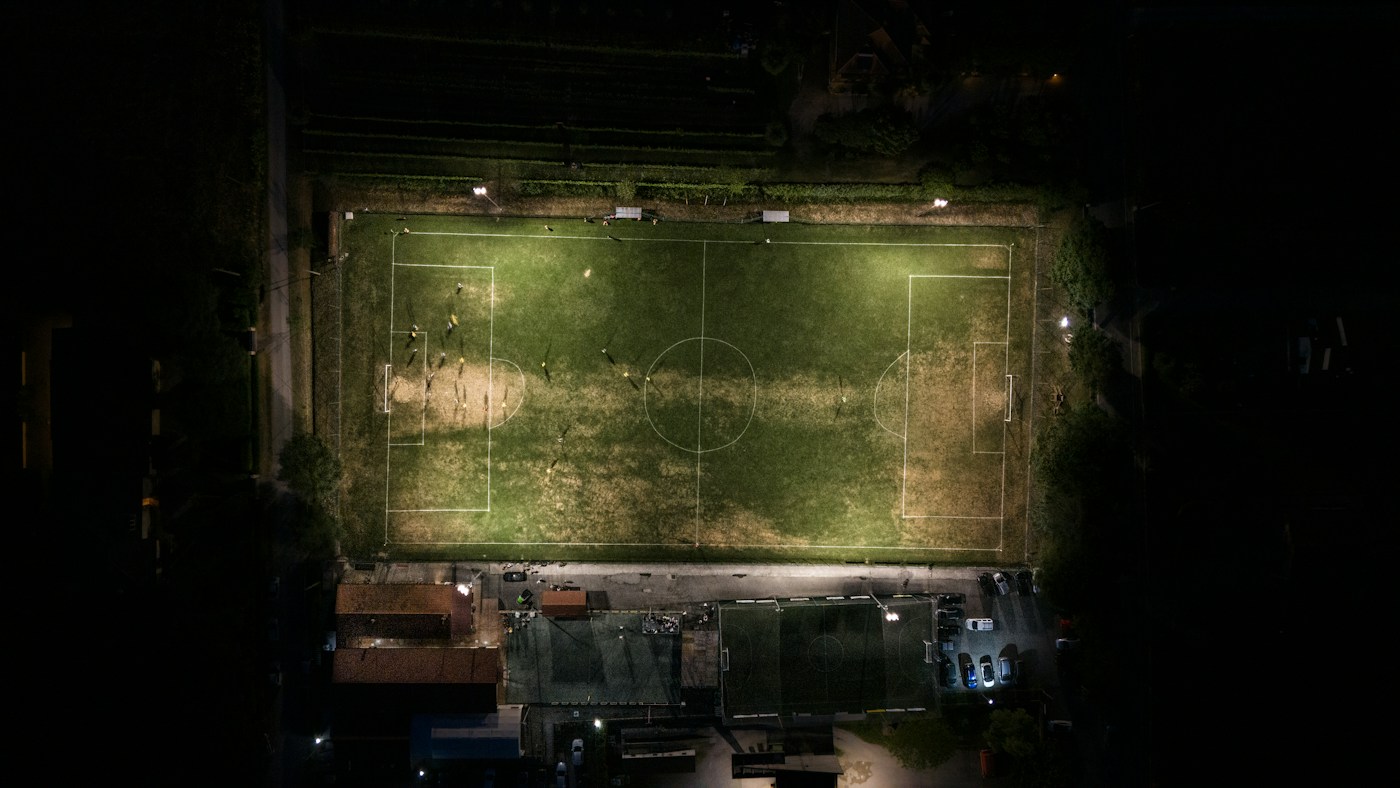 Cancha de fútbol iluminada de noche vista desde arriba