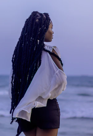Woman with long dreadlocks looking out at the ocean