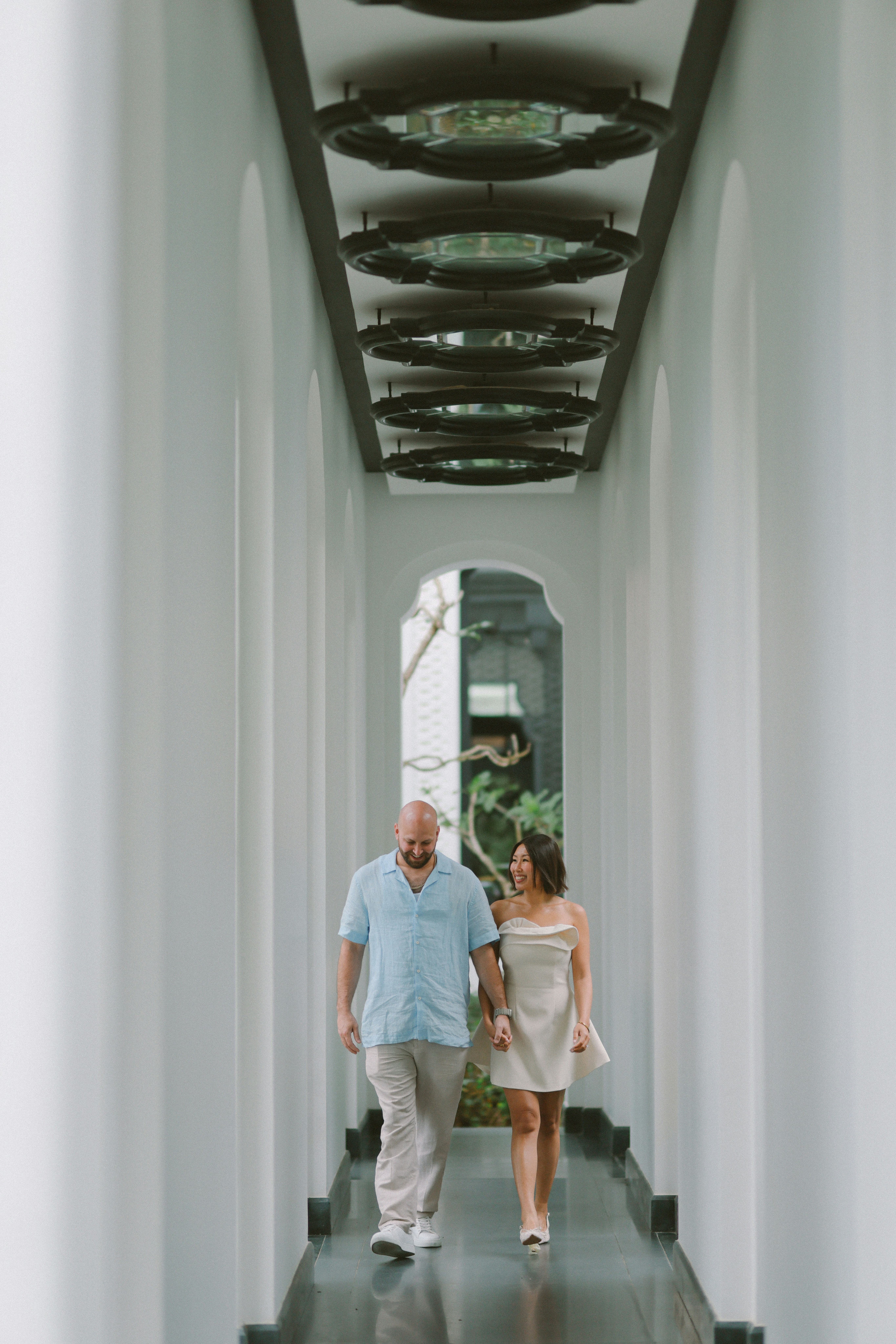 A couple walks hand in hand down a hallway