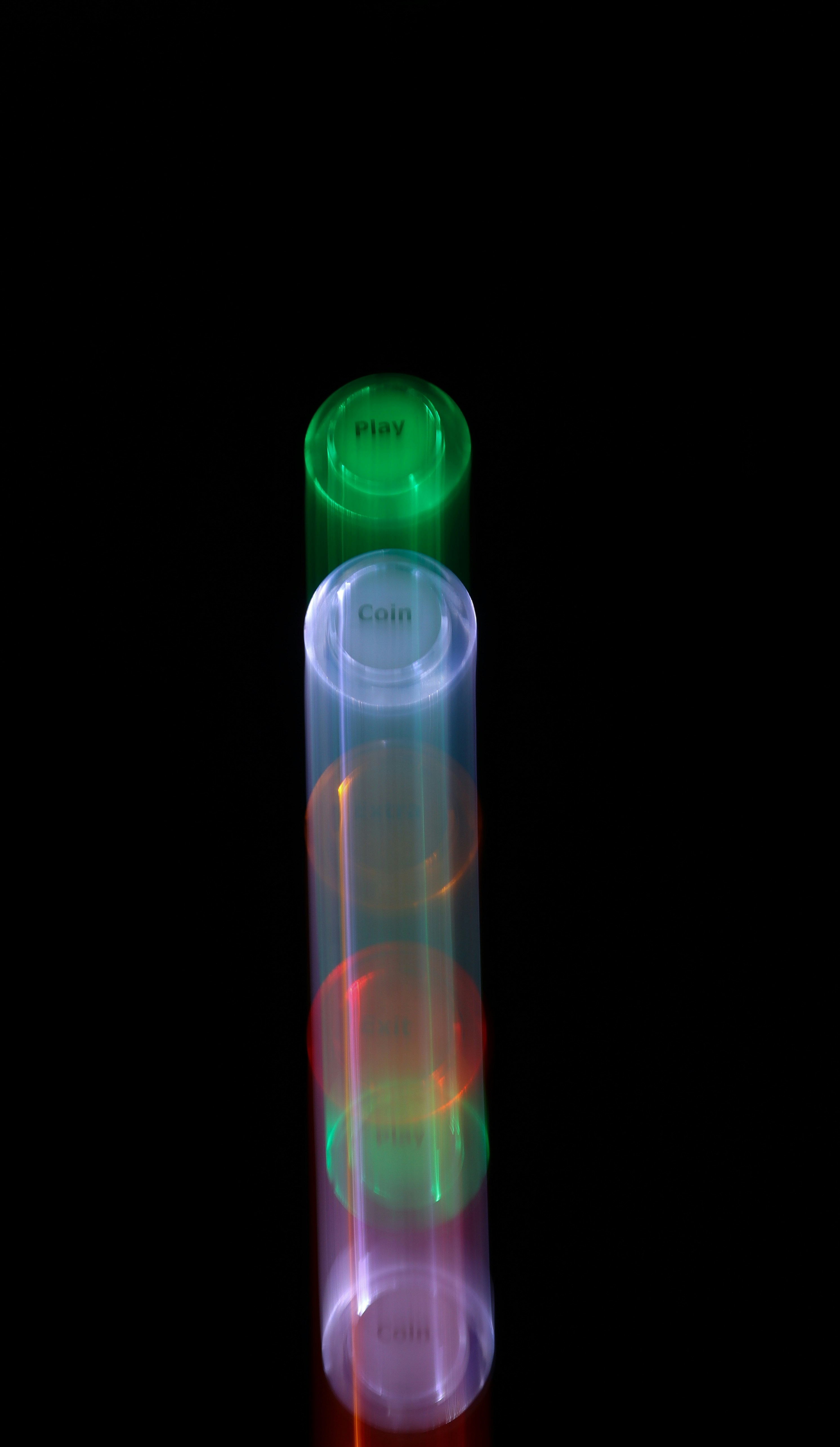 Two glowing tubes with buttons on black background