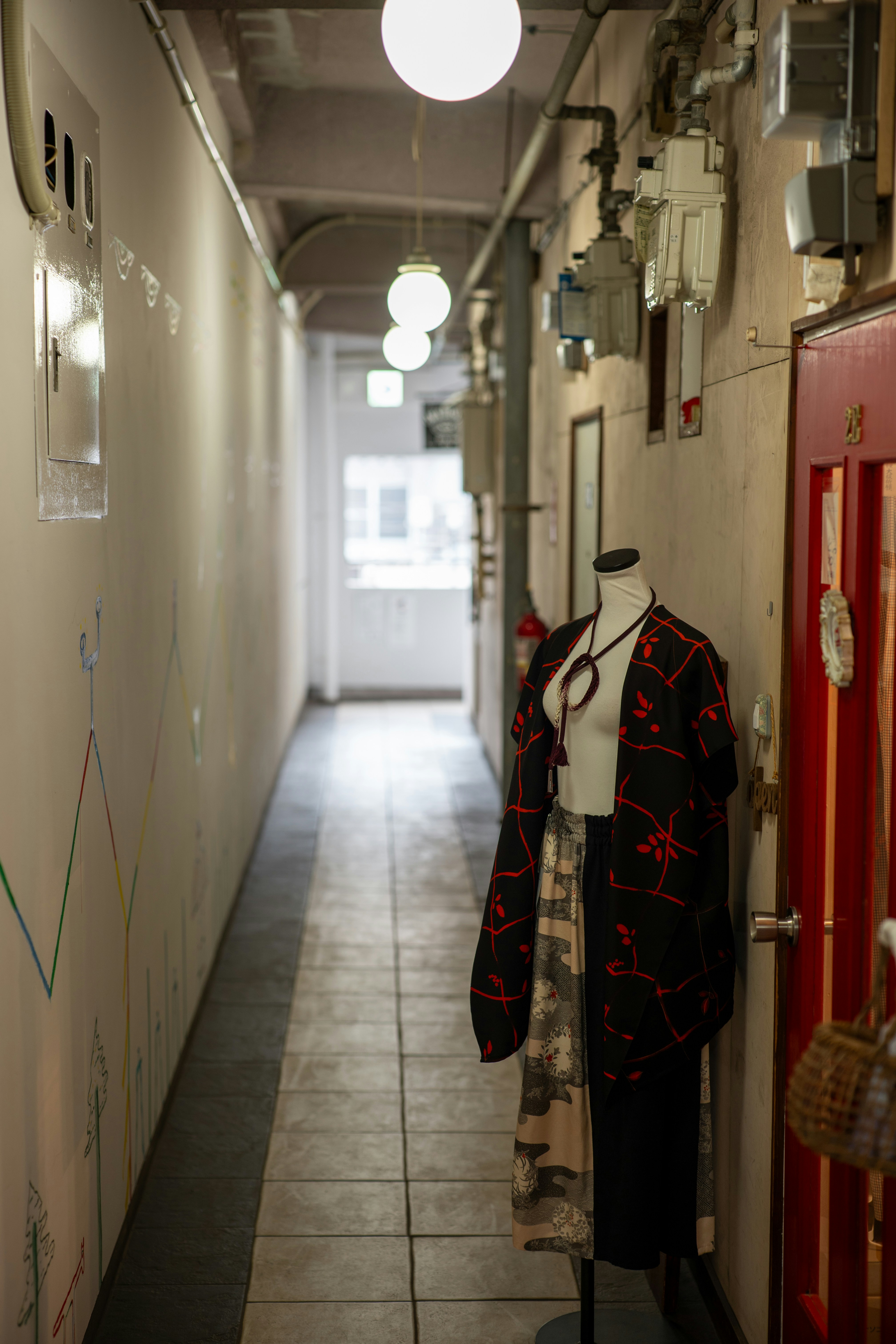 Mannequin wearing patterned clothing in a hallway.