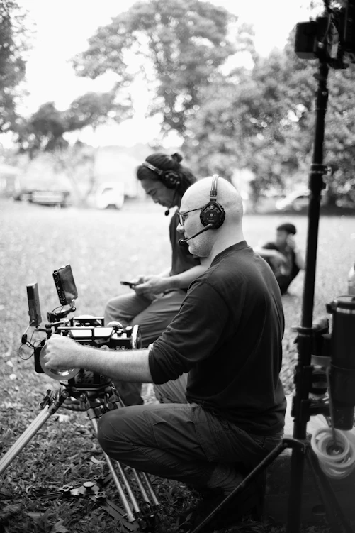 Two filmmakers operating camera equipment outdoors