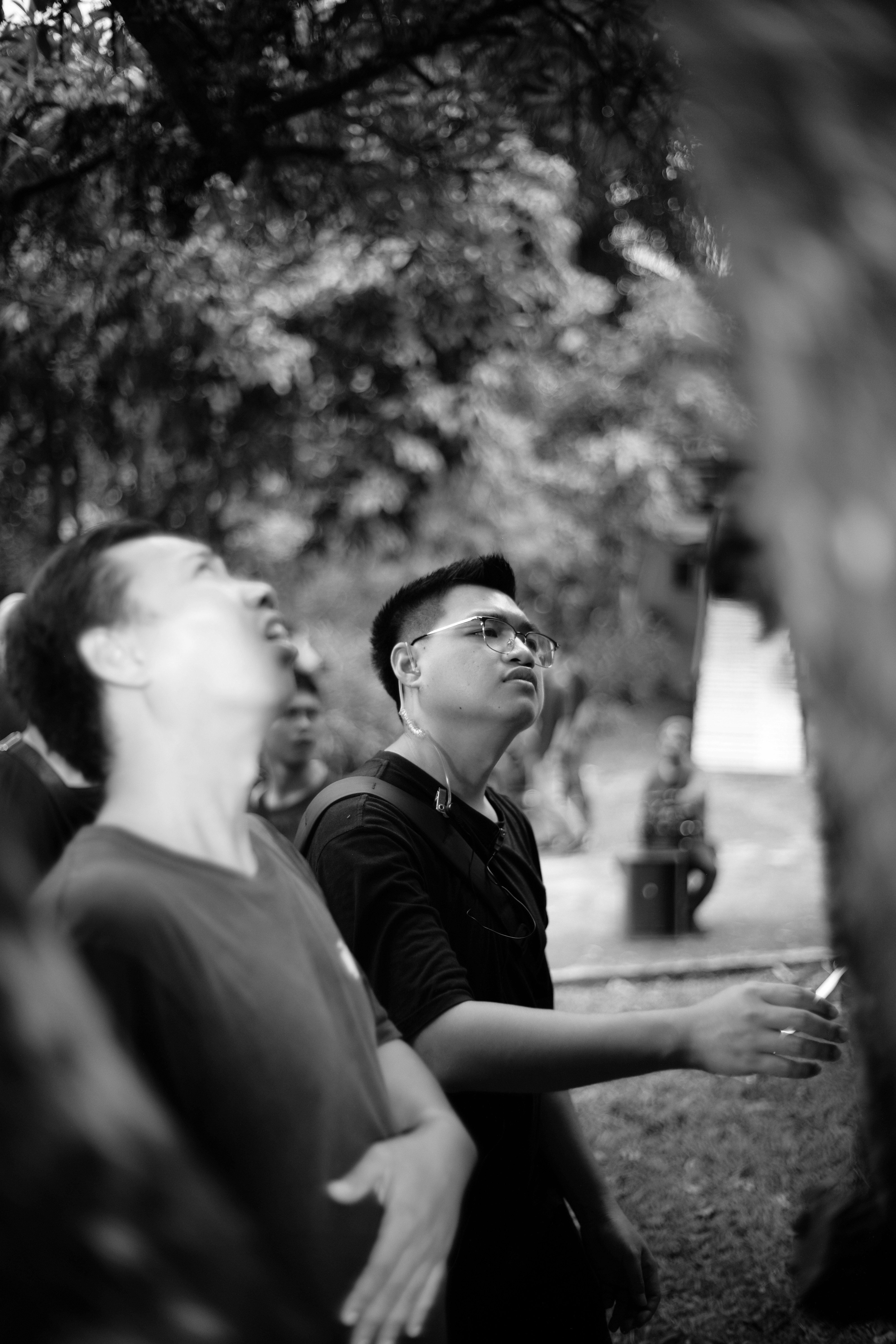 Dos hombres mirando hacia arriba en un entorno exterior.
