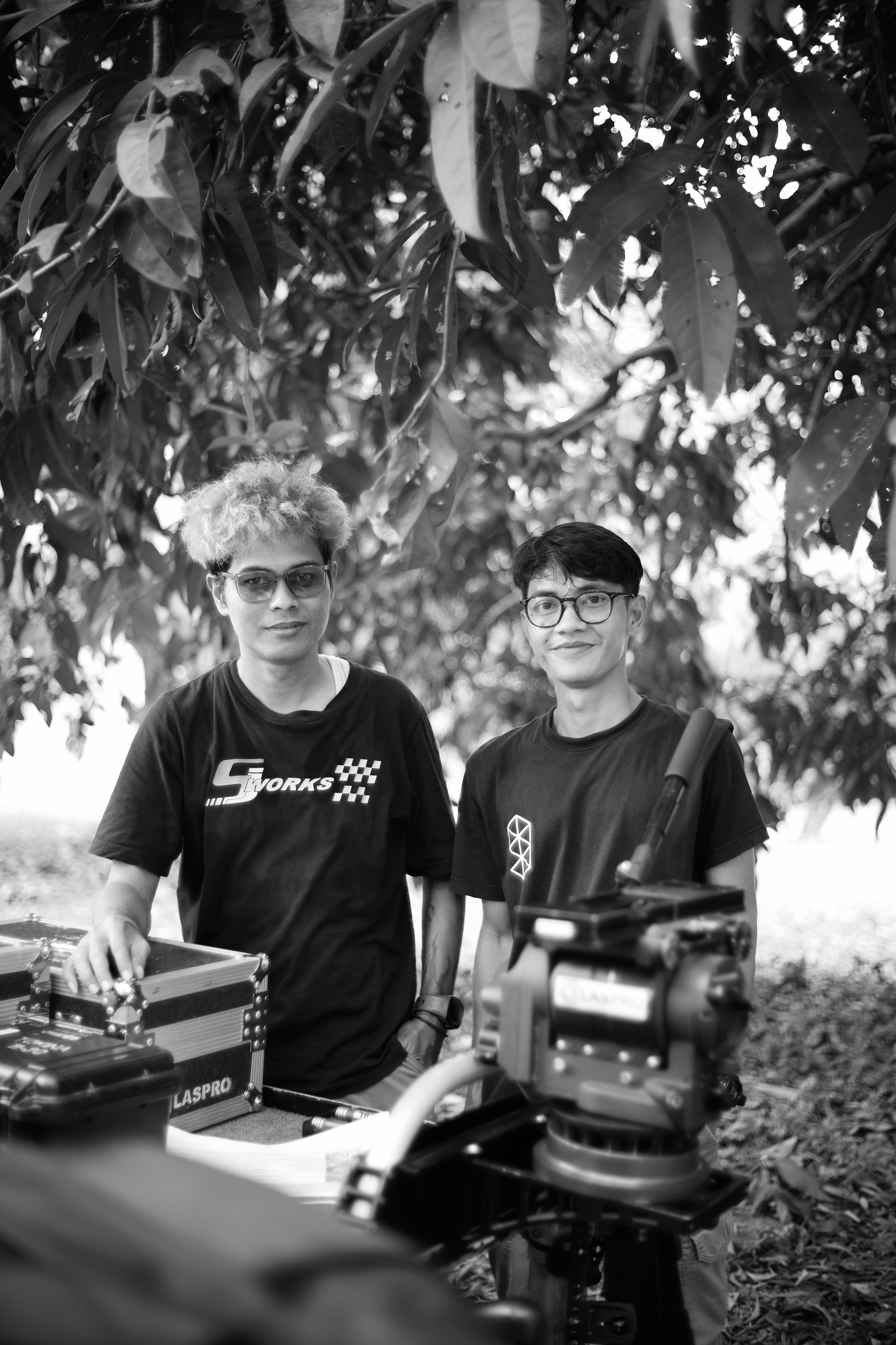 Two young men with filmmaking equipment outdoors.
