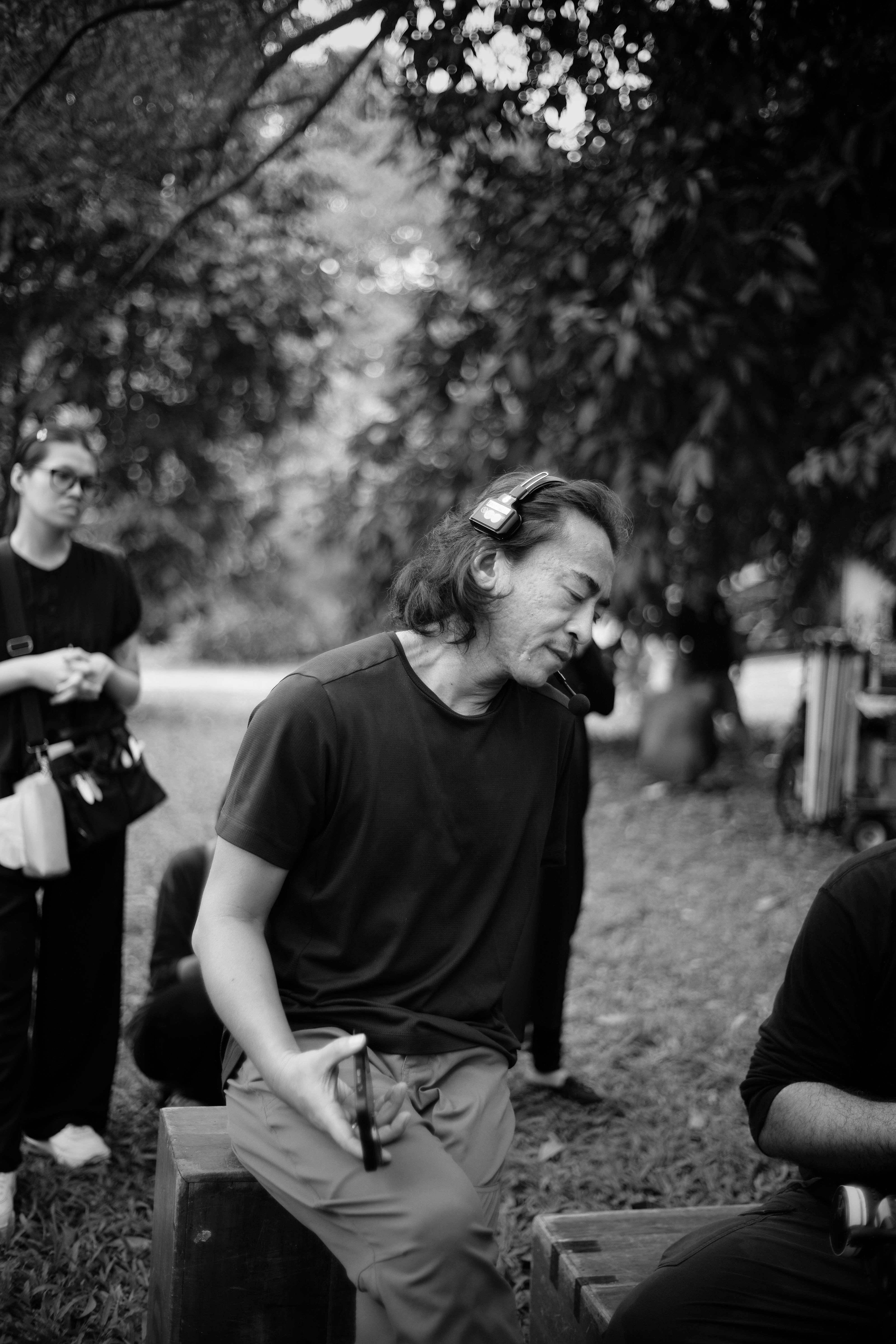 A man with long hair wearing headphones outdoors