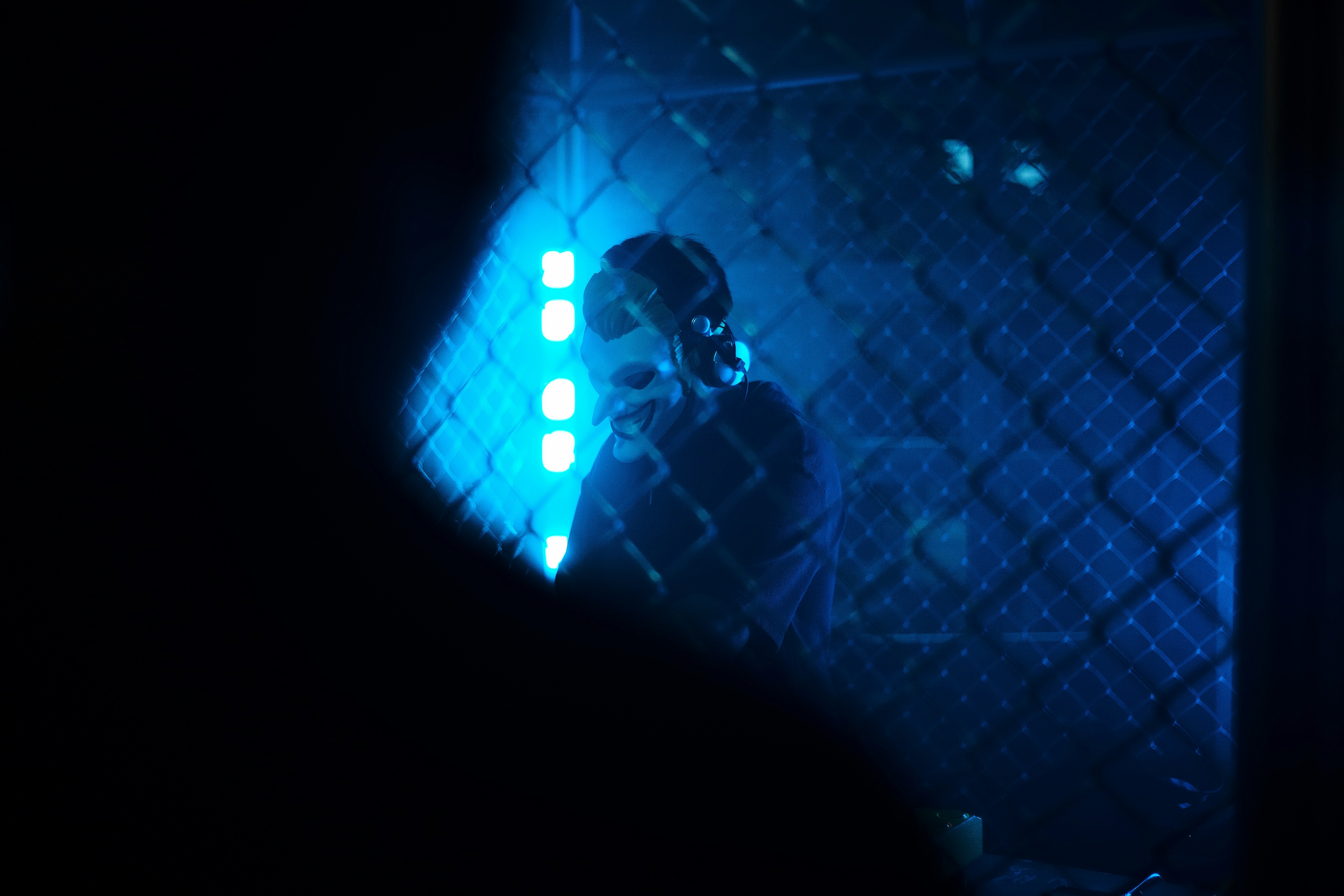 A person behind a fence with blue lights