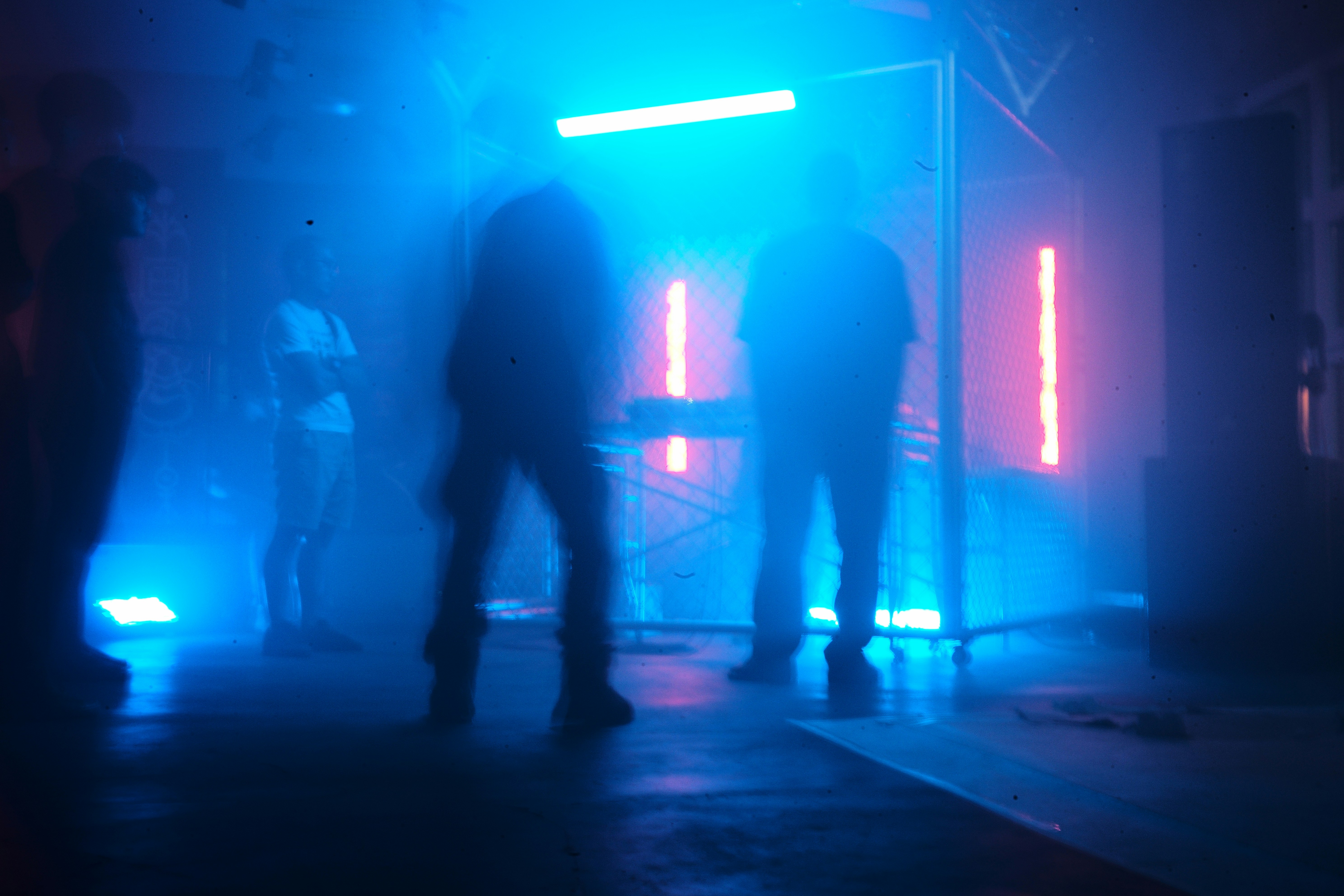 Silhouettes of people in a club with blue neon lights