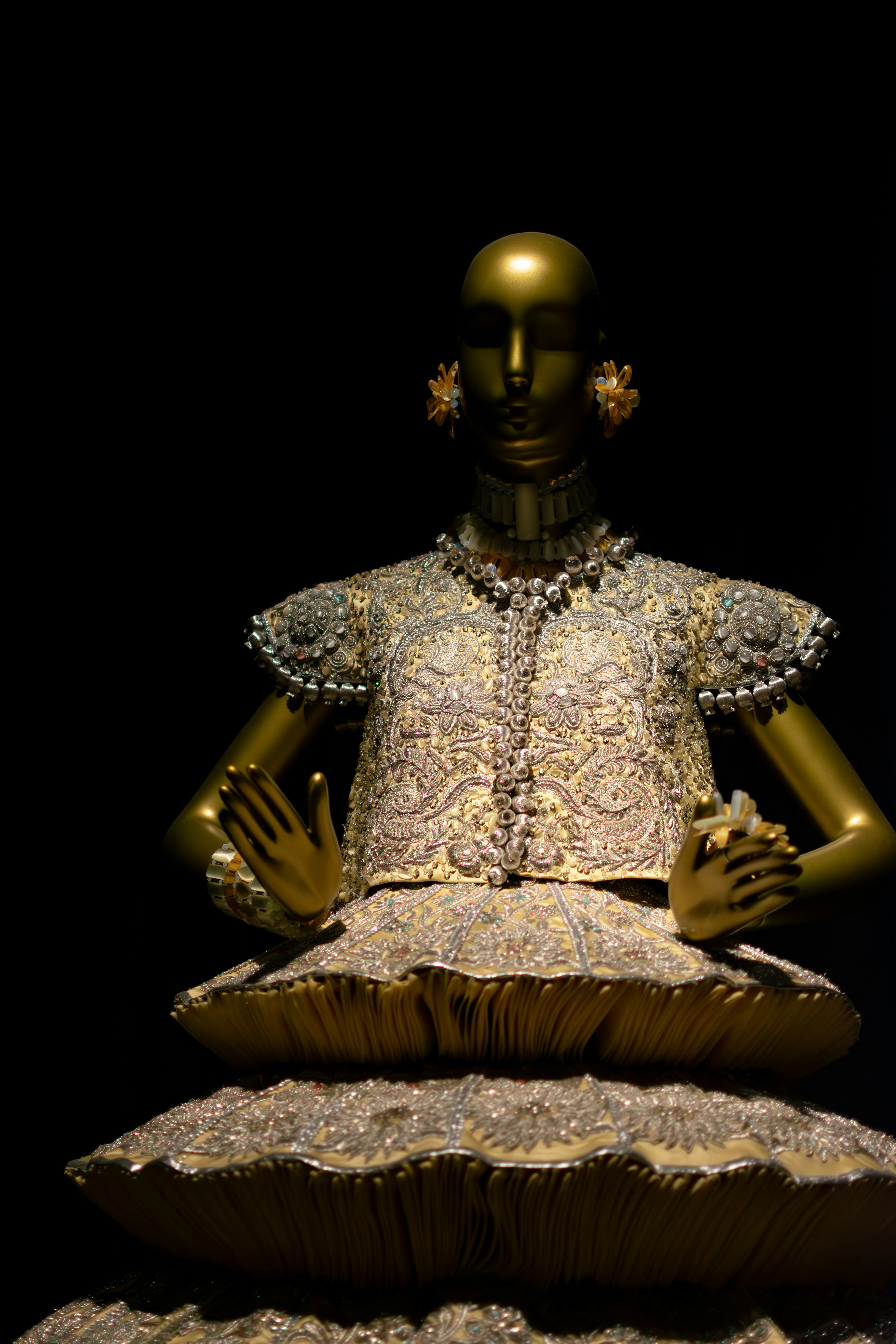 Golden mannequin displays ornate historical costume