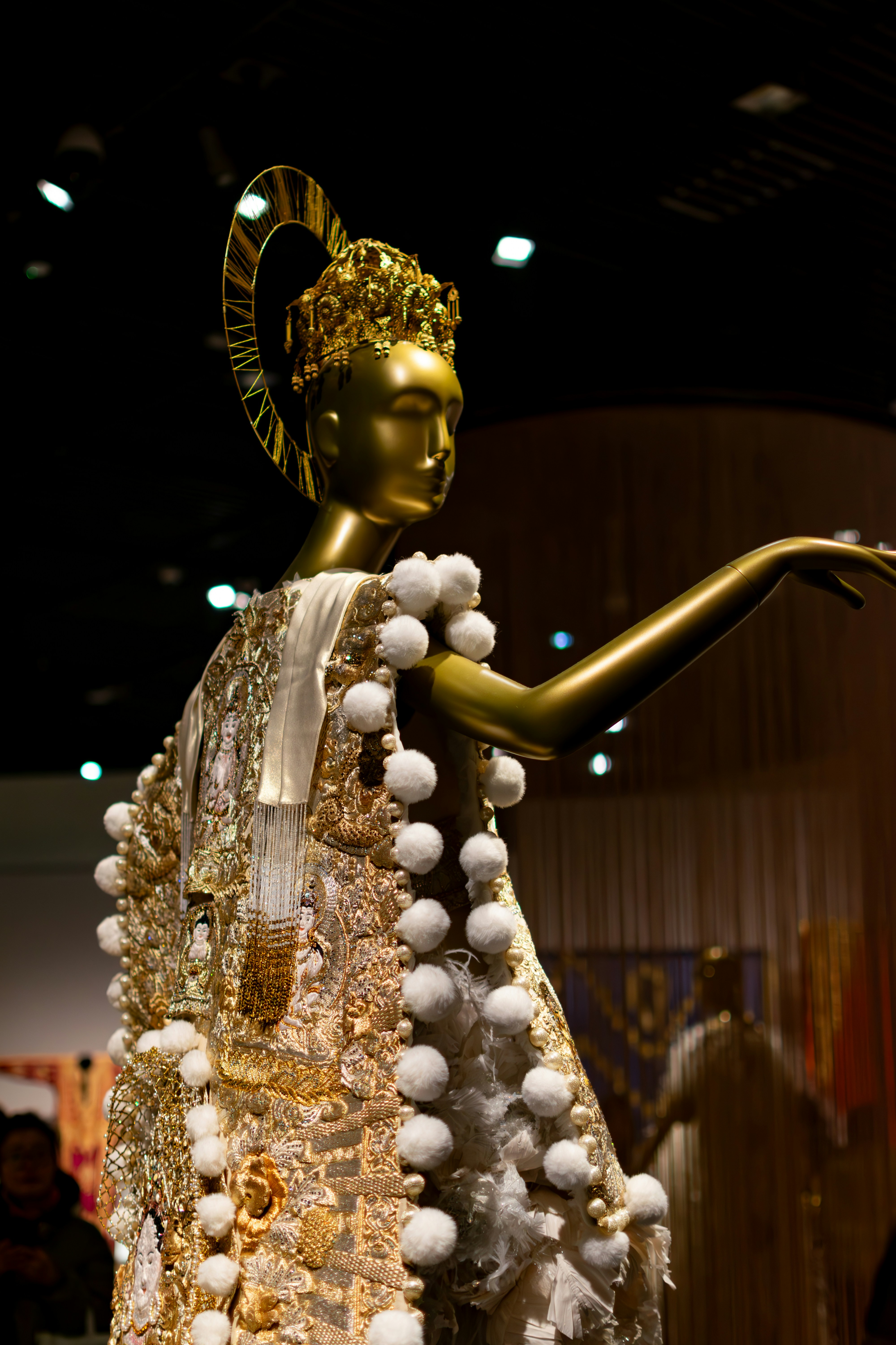 Golden mannequin wearing ornate, jeweled ceremonial robe
