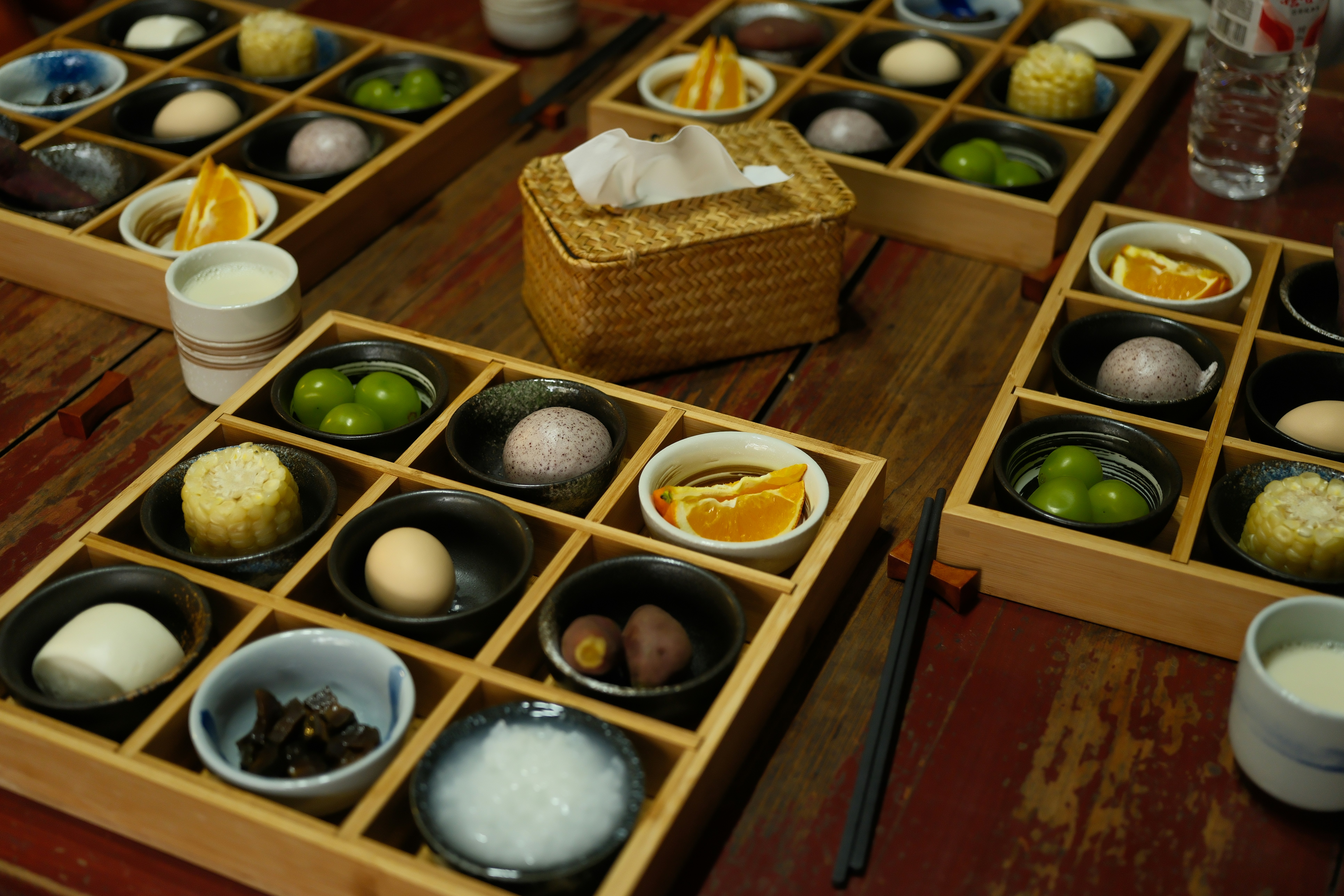 Assortment of small dishes in wooden trays on table