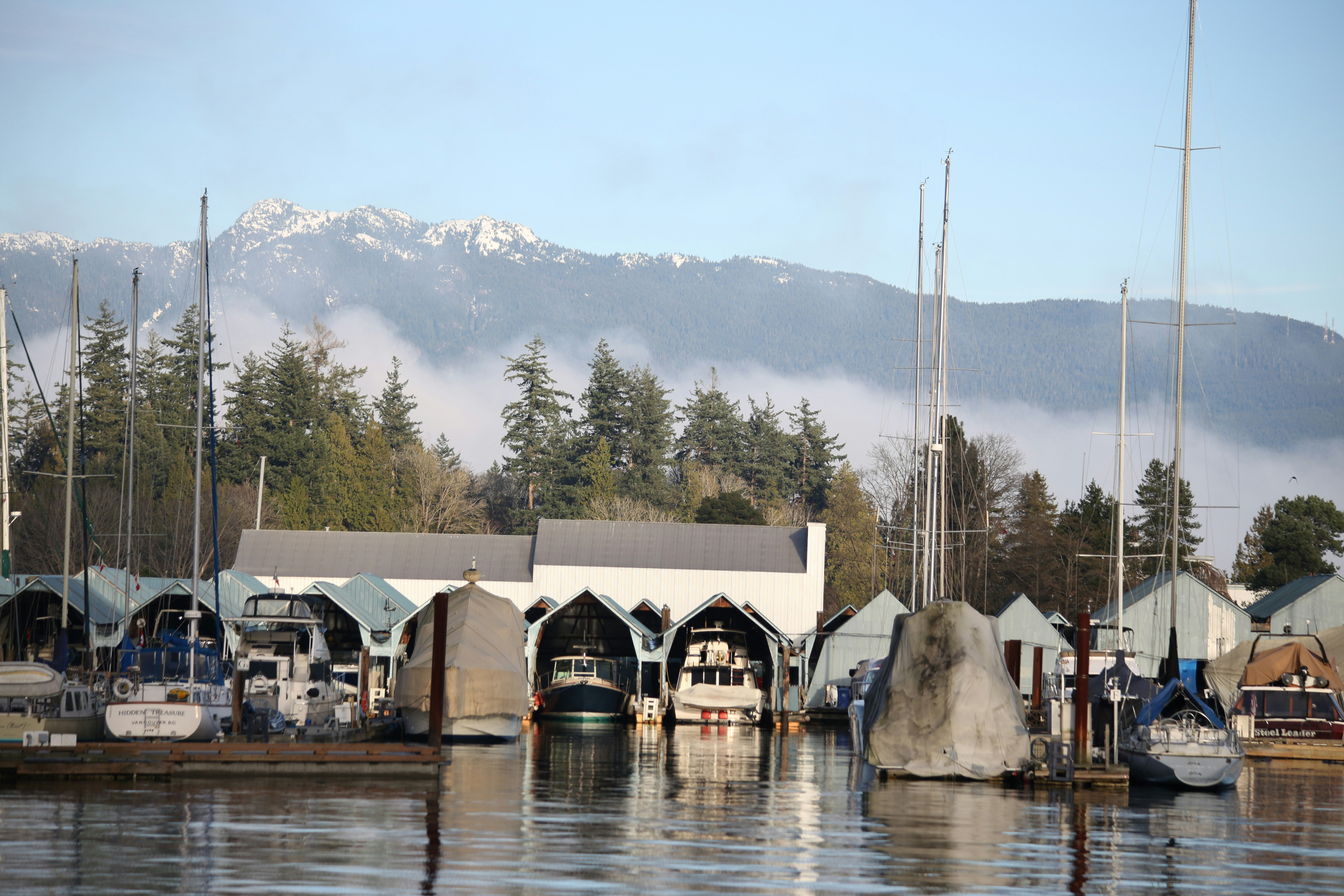 Boats docked at a marina with mountains in background