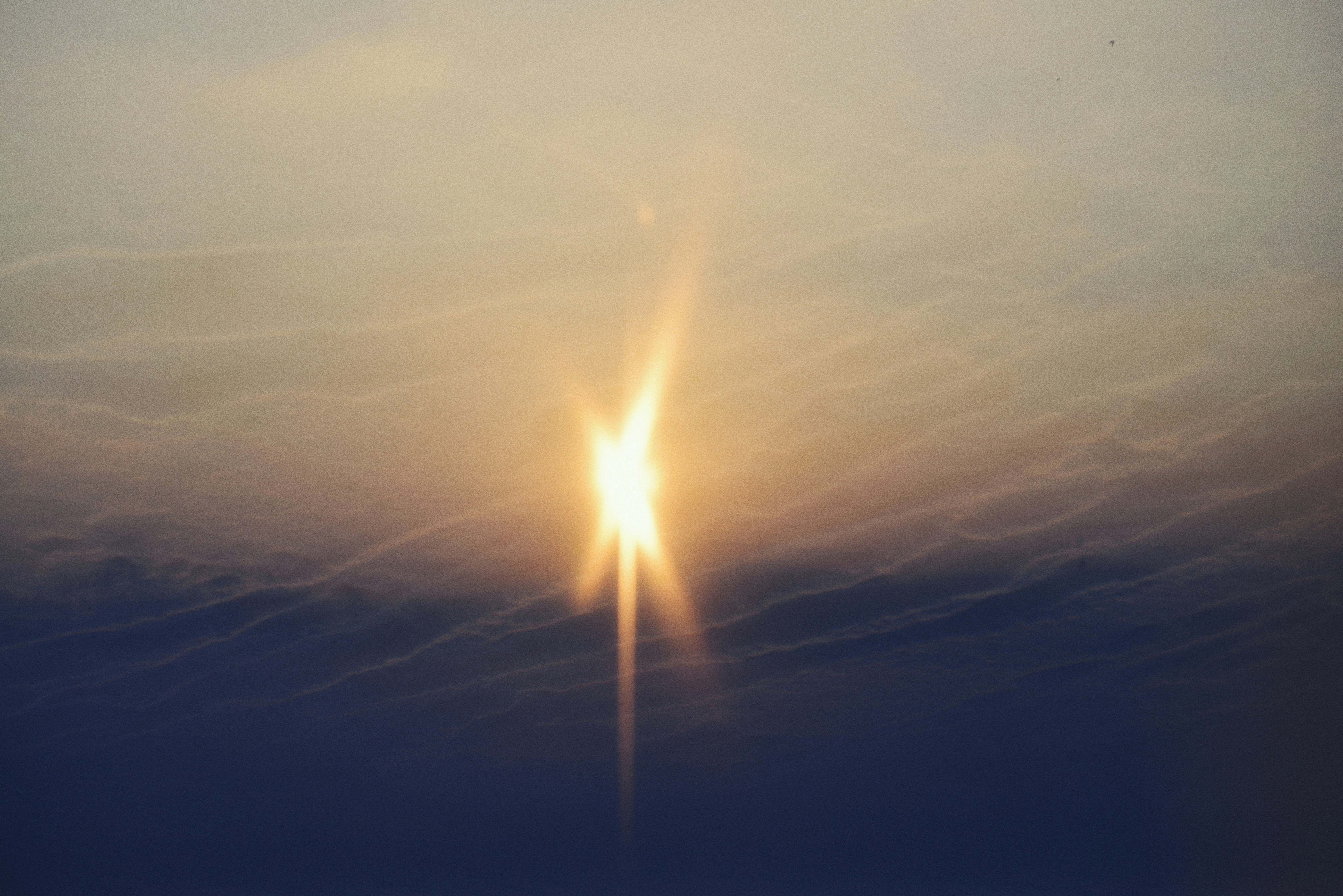 해질 무렵, 흐릿한 구름 사이로 밝은 햇살이 비치고 있다