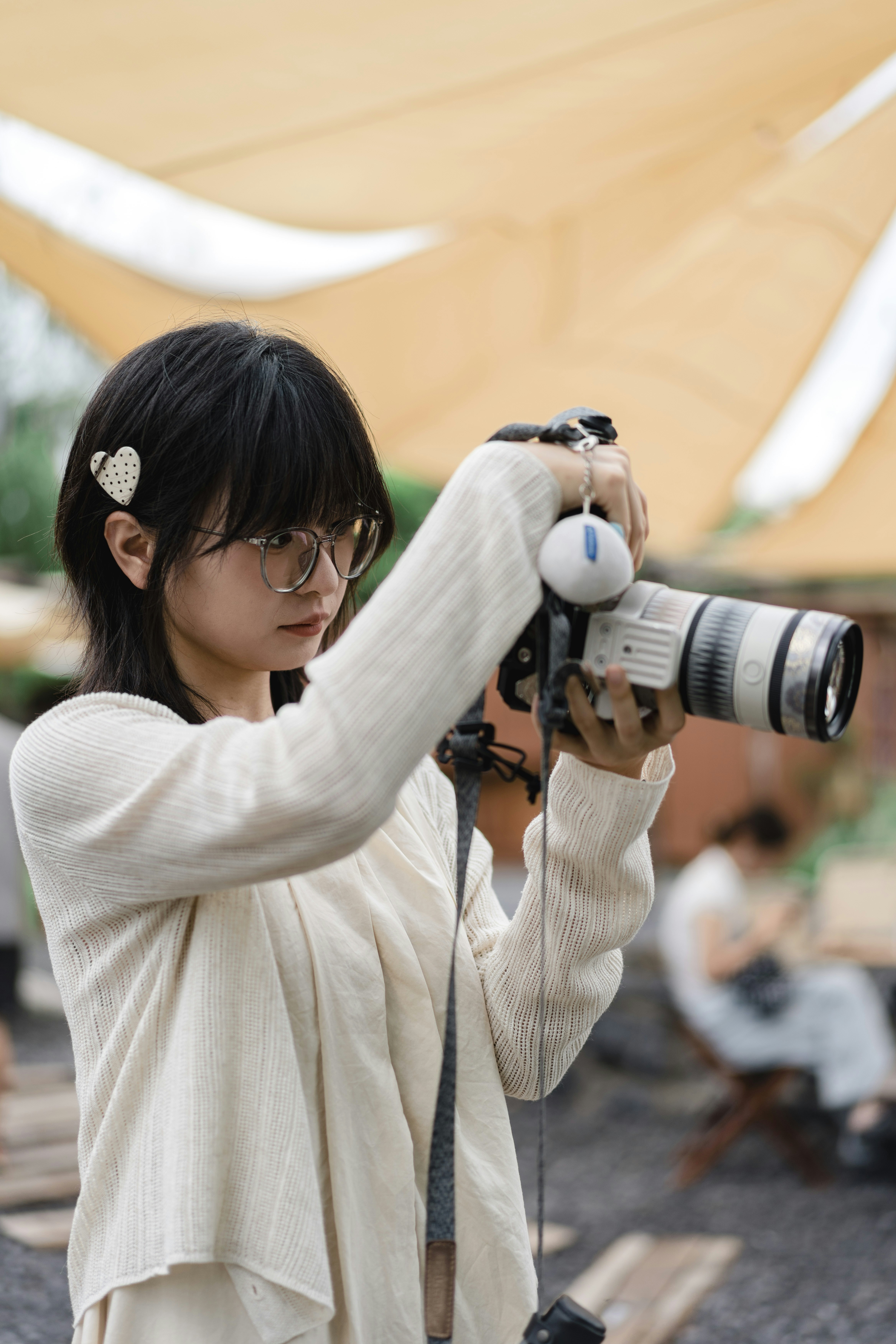 Young woman with glasses taking a photo with camera