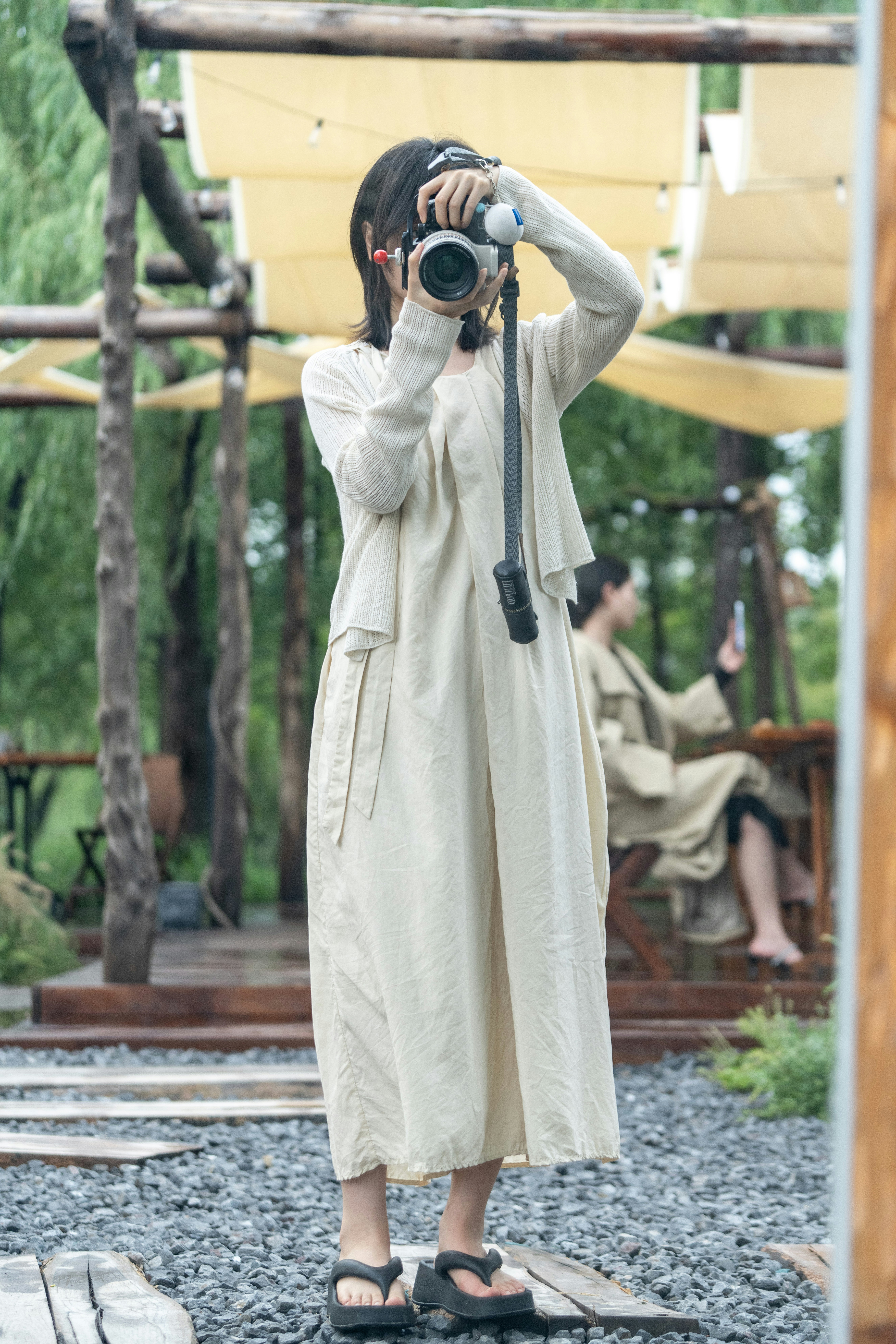 Woman taking a photo in an outdoor cafe