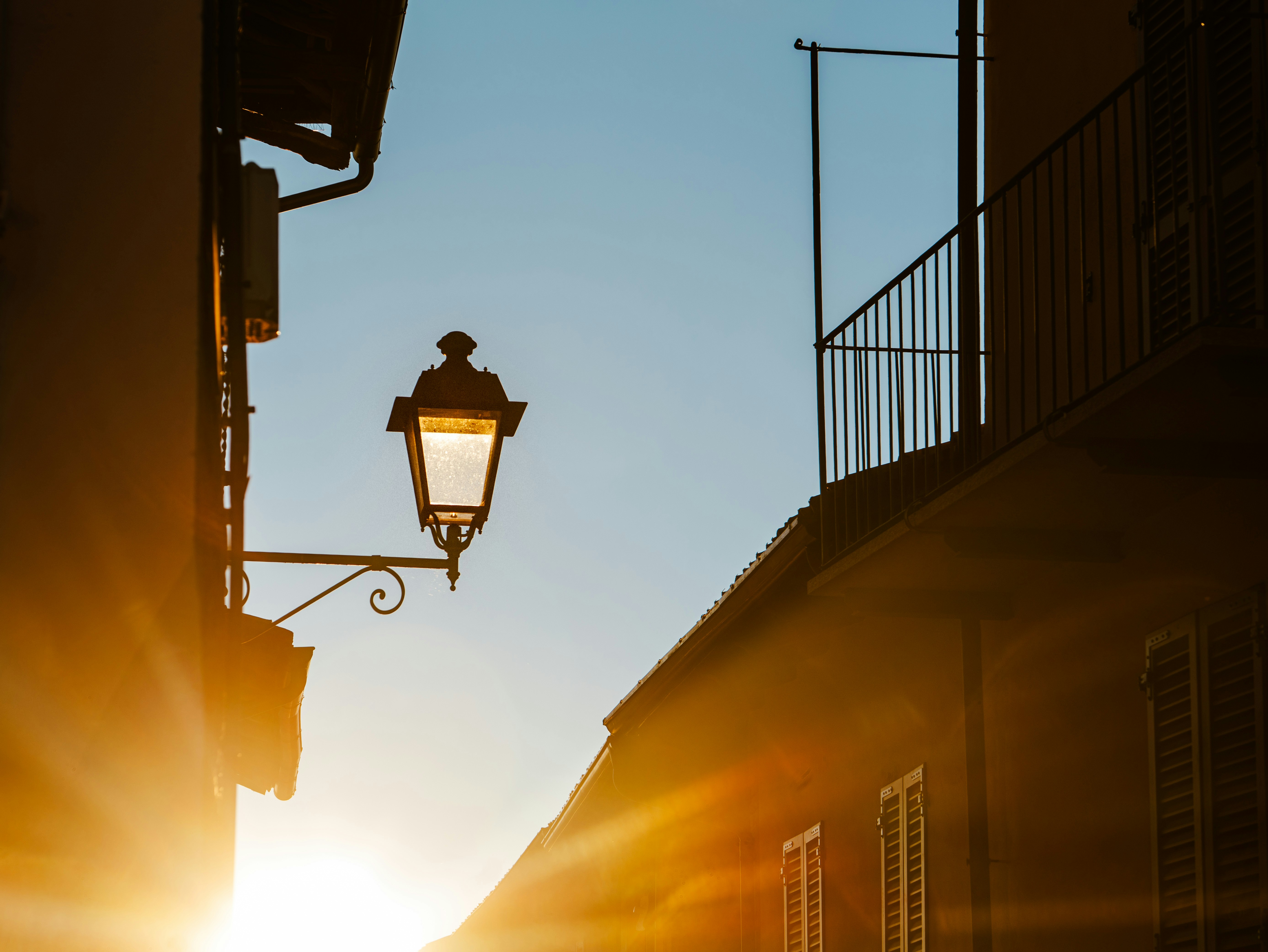Old street lamp illuminated by warm sunset light