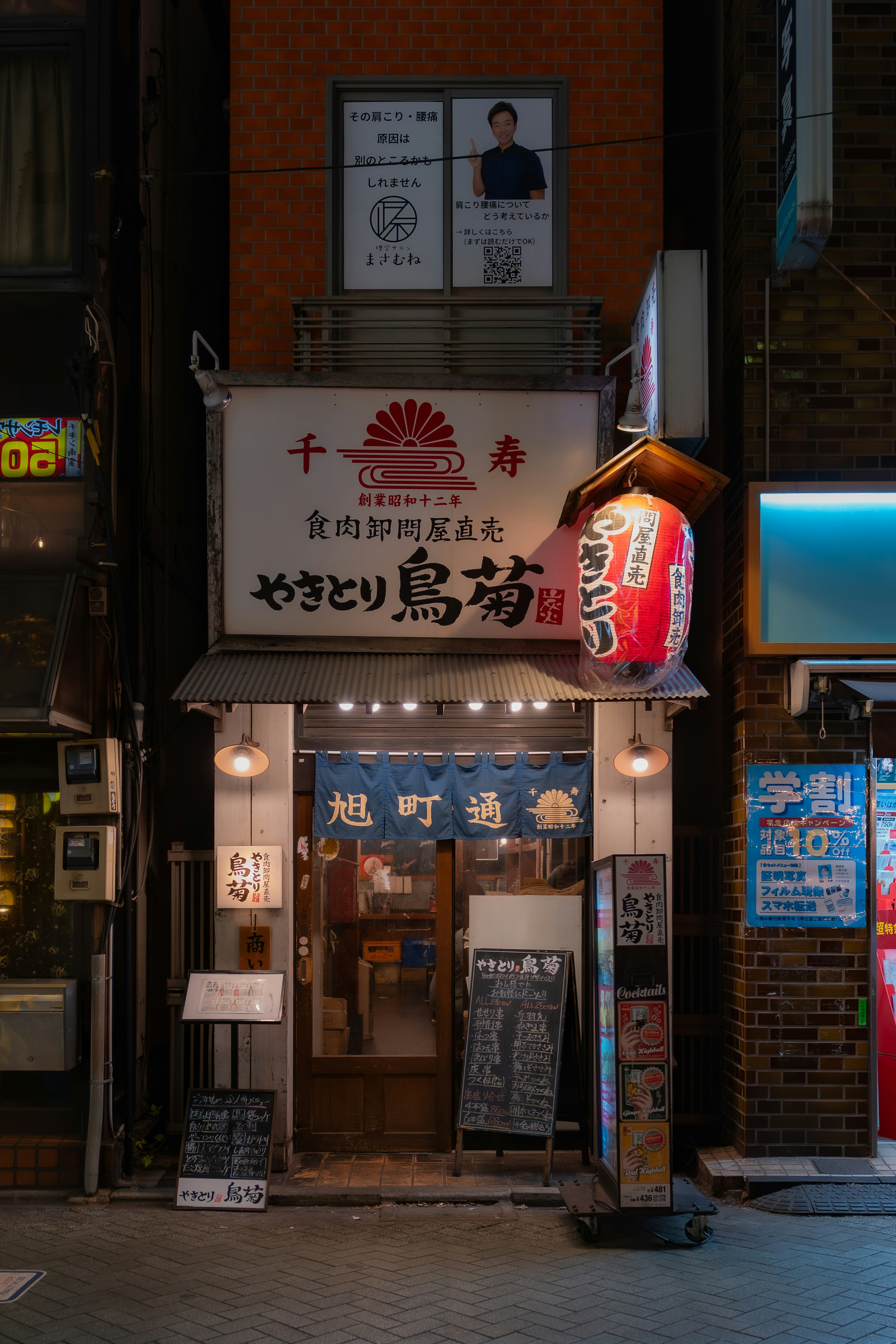 Japanese restaurant entrance at night with red lantern.