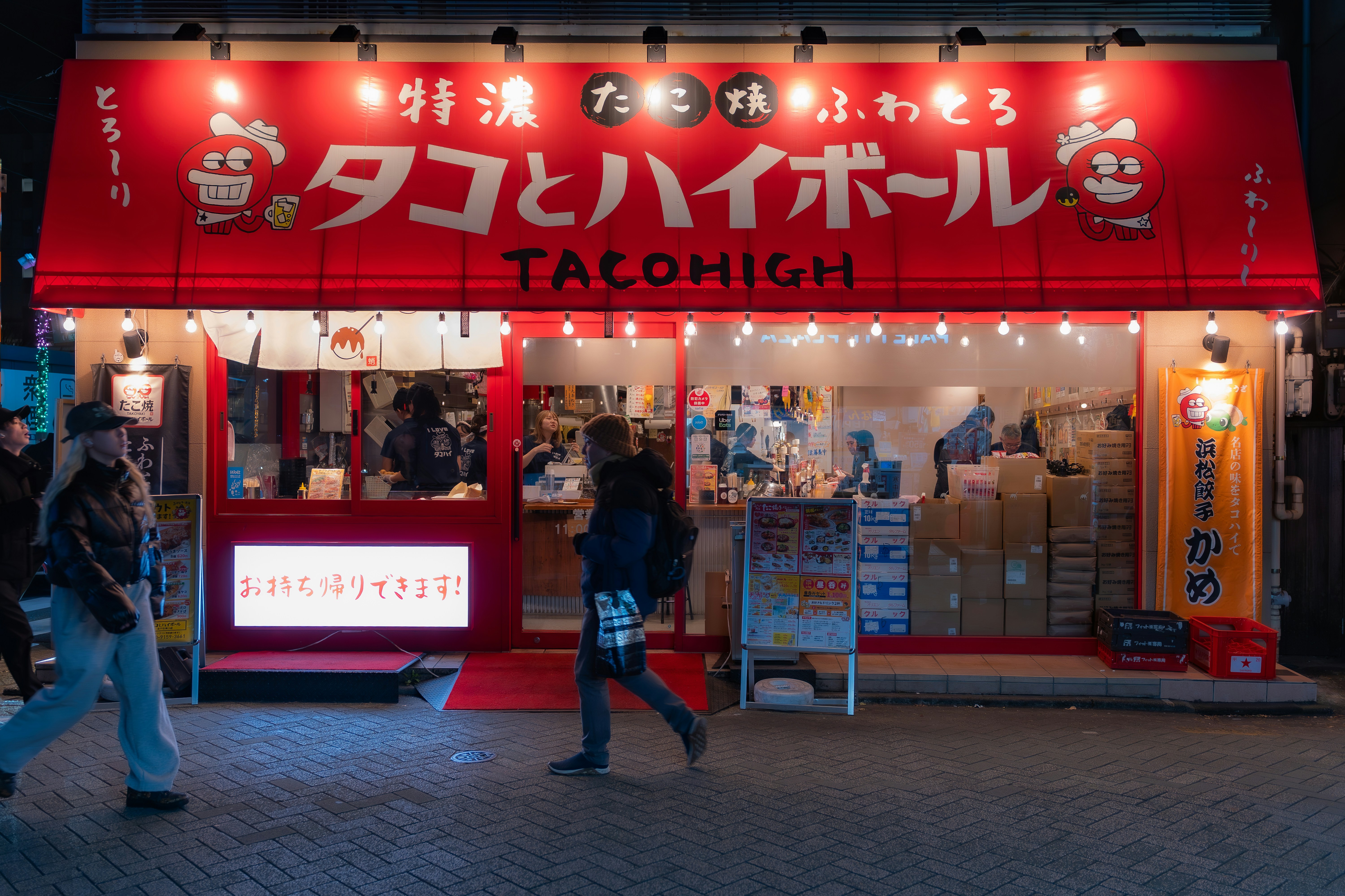 Taco and highball restaurant storefront at night