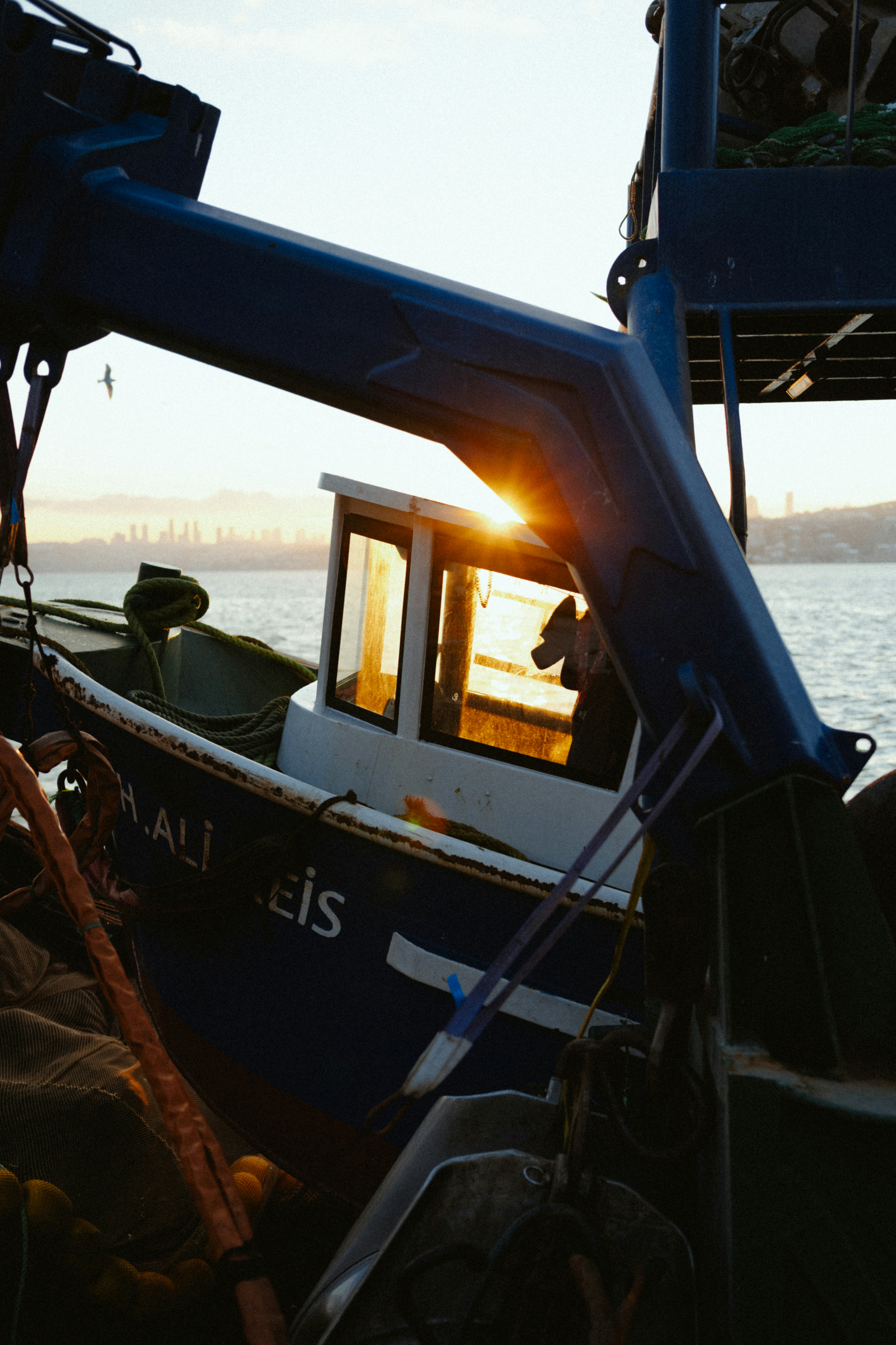 Fishing boat at sunset with sun flare.