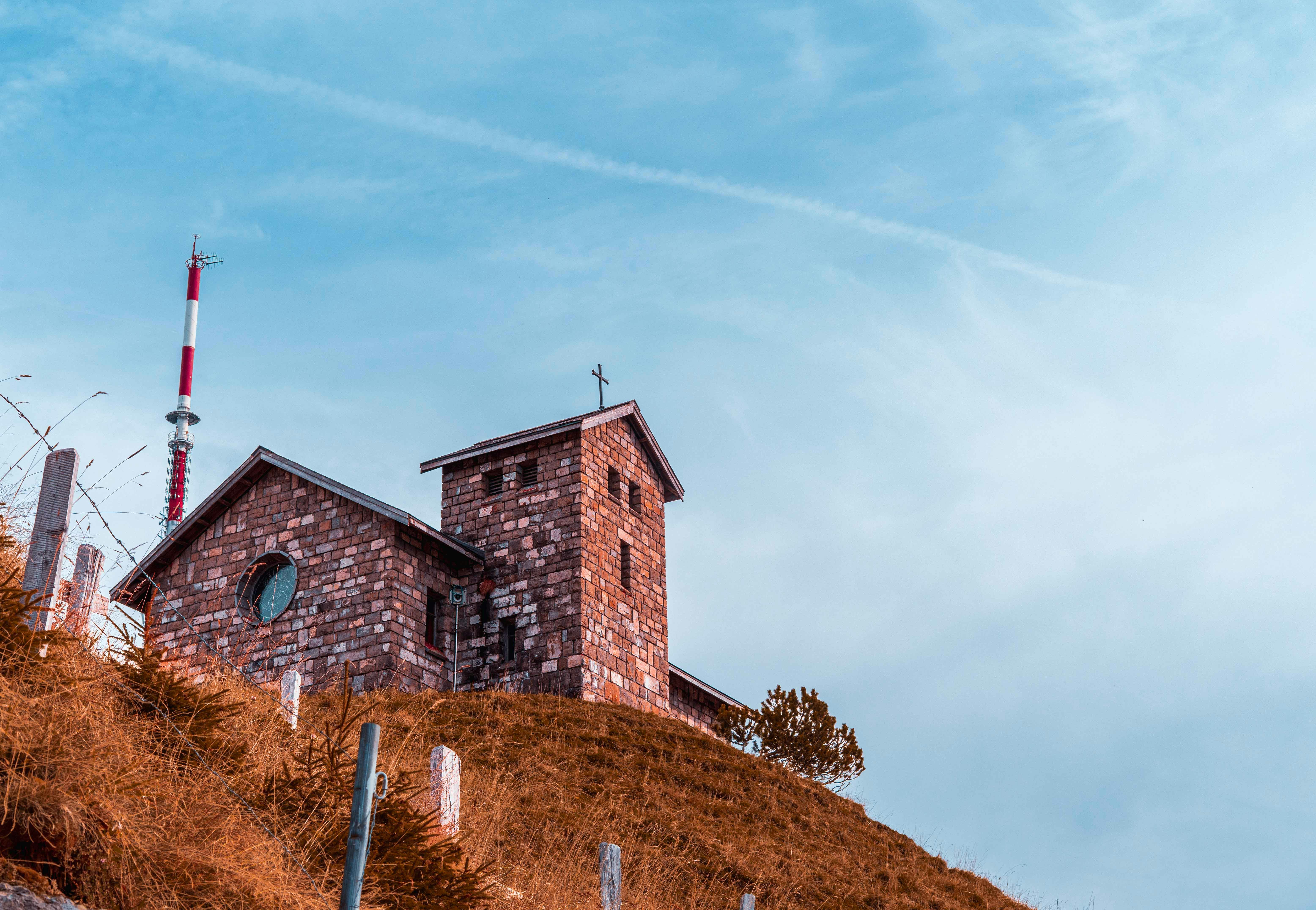 Stone building with tower on a grassy hill